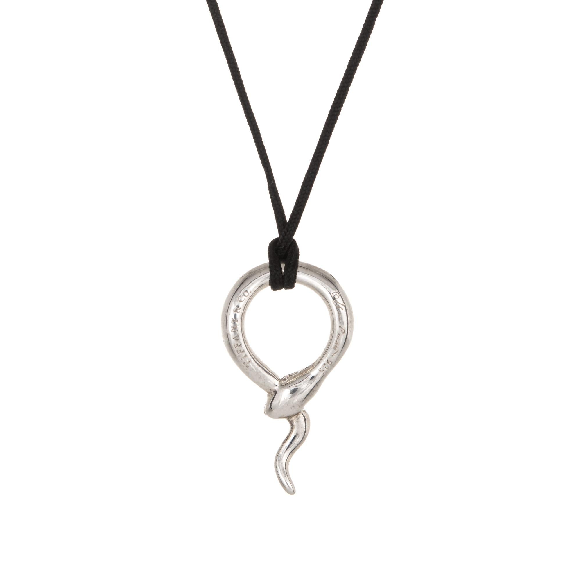 Finely detailed pre owned Tiffany & Co snake necklace crafted in sterling silver.  

The ouroboros snake is hung from black silk cord. The necklace is in very good condition and was recently professionally cleaned and polished.