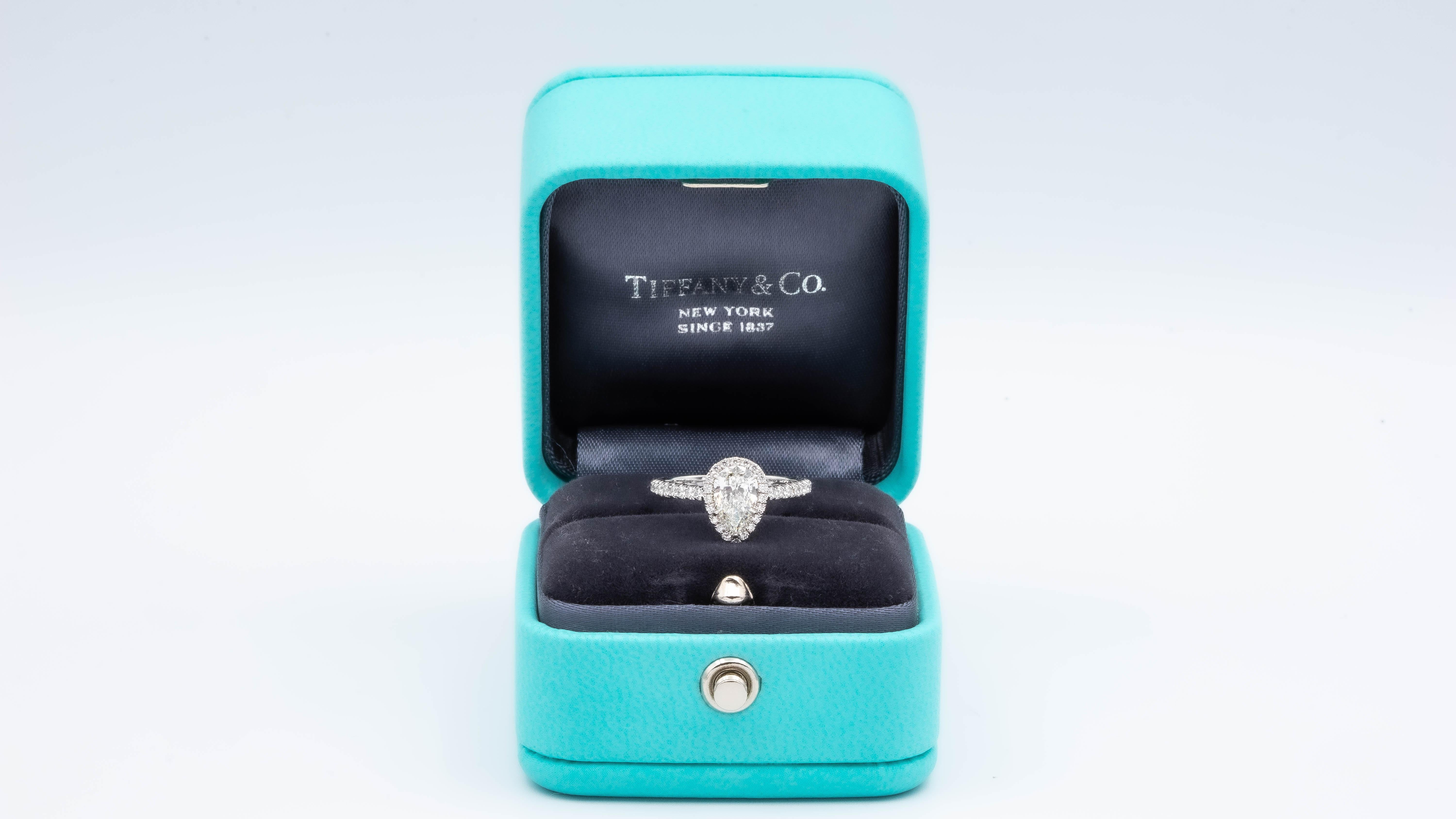 Tiffany & Co. Soleste Diamond Engagement ring featuring a 0.69 ct Pear Shape Center diamond finely crafted in Platinum, accented by a bead set diamond halo and shank with 40 round brilliant cut diamonds weighing 0.40 cts. total weight