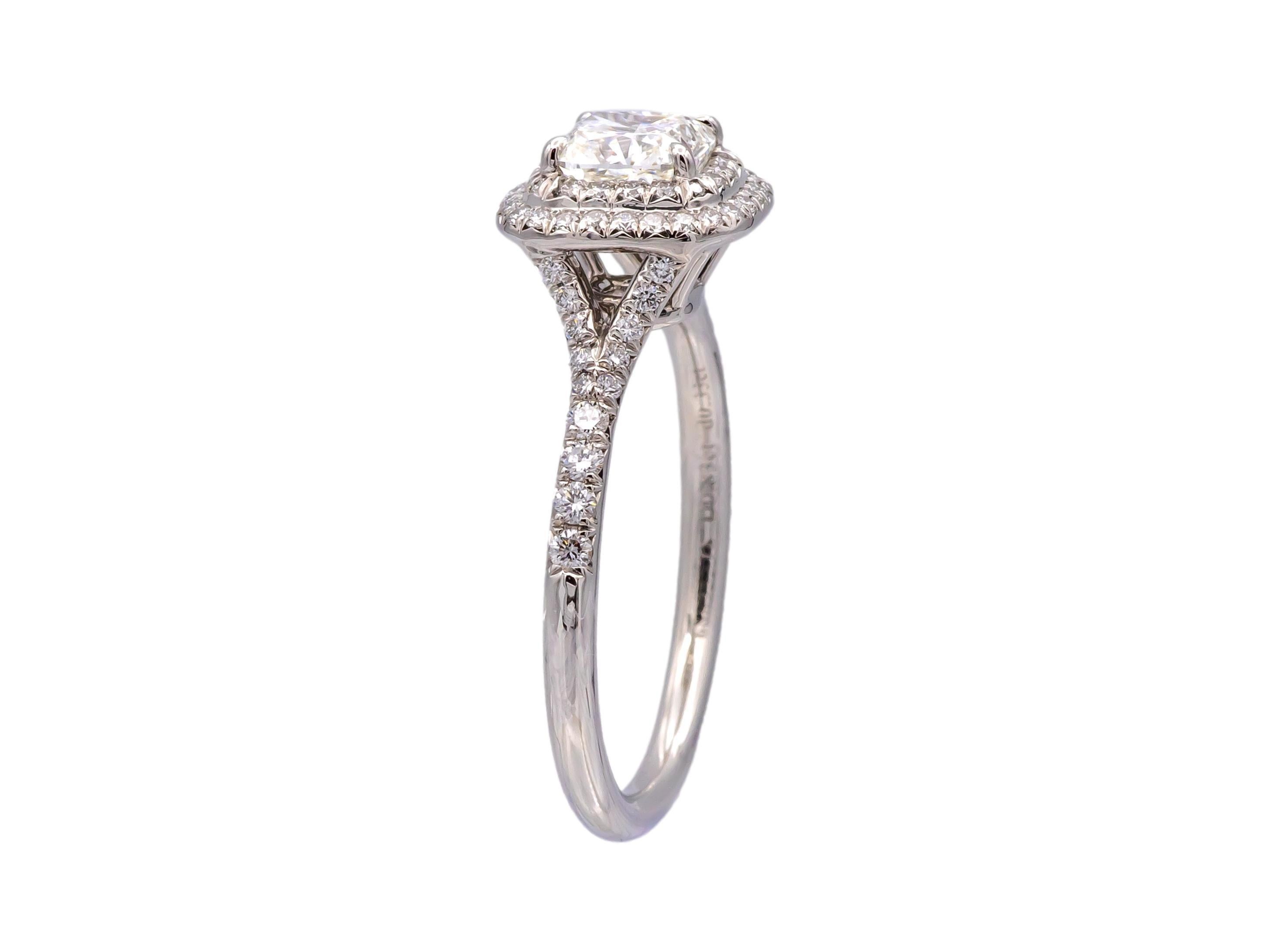 This Tiffany & Co. Soleste Ring is crafted in platinum and features a 0.83-carat cushion-cut center diamond, surrounded by a diamond halo of 0.33 carats of F/VVS diamonds, . The center diamond is graded F color, VVS2 clarity and boasts excellent