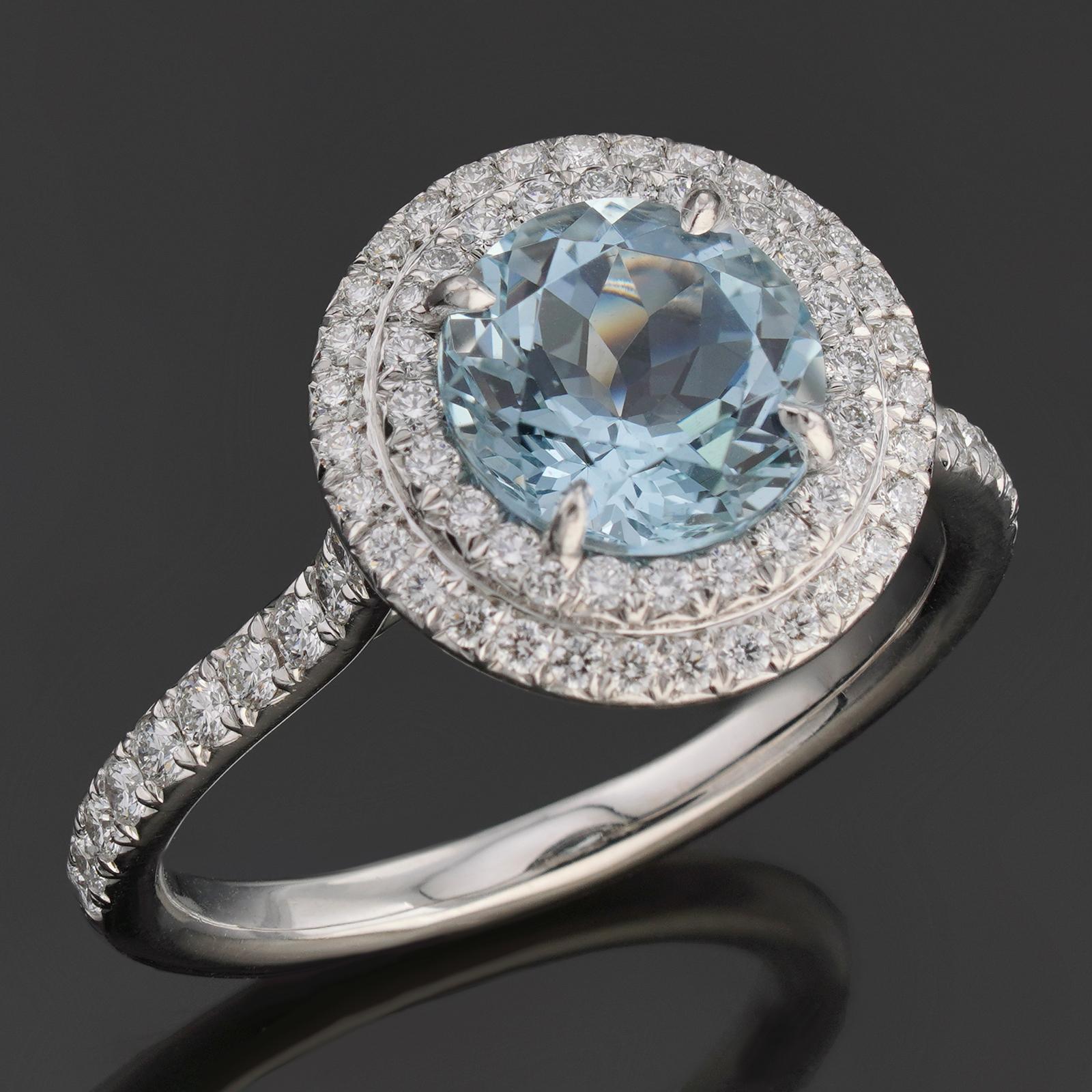 This exquisite Tiffany & Co. ring from the sophisticated Soleste collection is crafted in platinum and set with an intensely colored blue aquamarine surrounded with two rows of brilliant-cut round diamonds. The round 5.0mm x 8.0mm x 8.0mm aquamarine