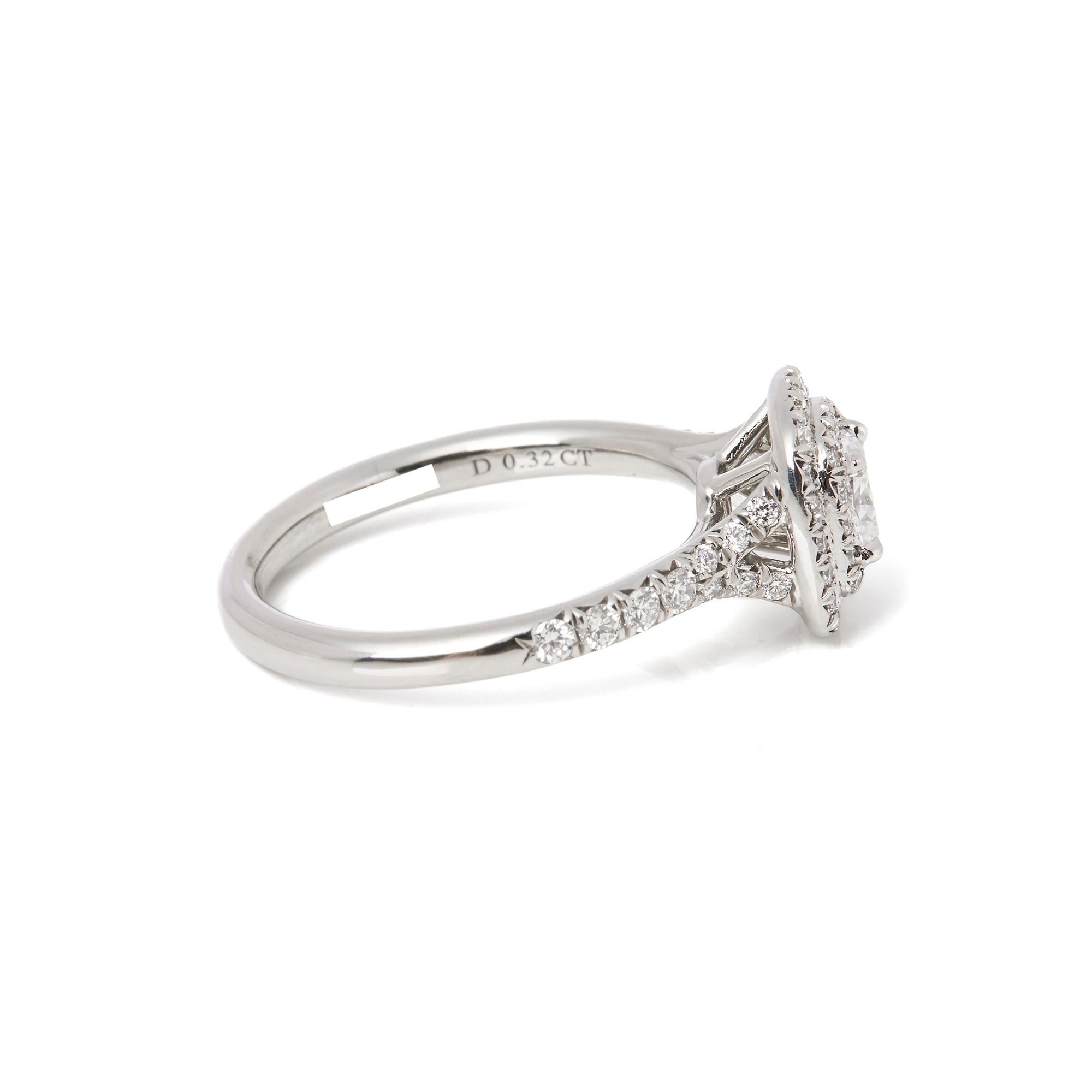 This engagement ring by Tiffany & Co is from their Soleste collection and features 1 cushion cut diamond totalling 0.32ct surrounded by a double halo of round brilliant diamonds with further diamonds on the shoulders of the ring. It is accompanied