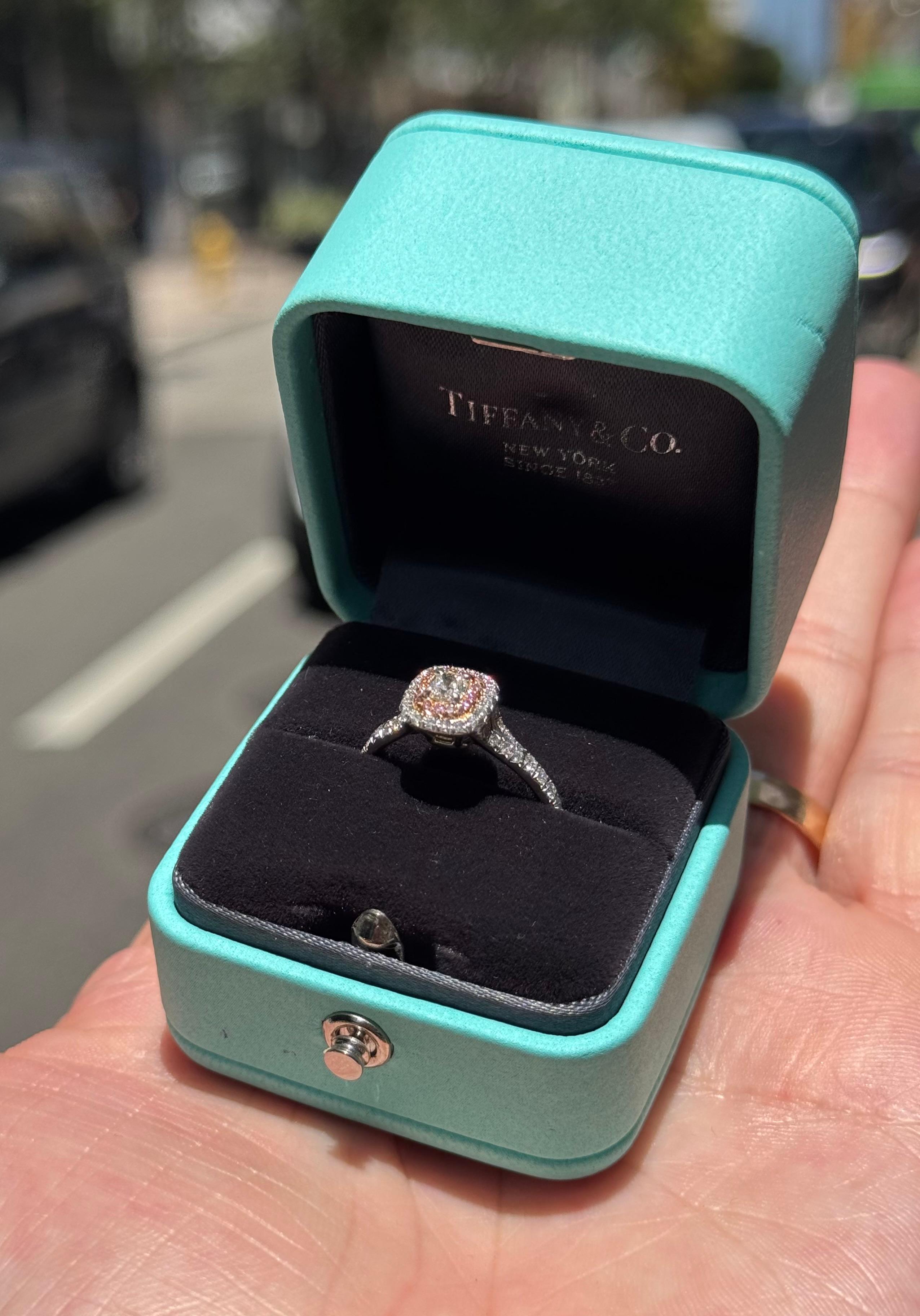 Un elegante anello di fidanzamento del famoso designer Tiffany & Co. L'anello della collezione Soleste è finemente realizzato in platino e oro rosa 18 carati e mette in risalto una gemma centrale di diamante taglio cuscino da 0,23 carati estratta in