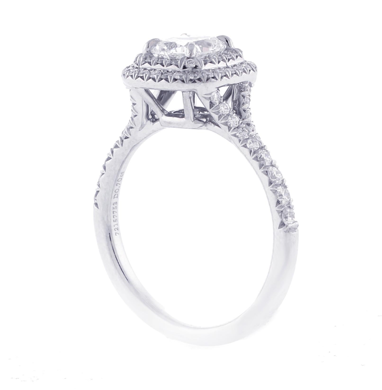 L'anello con diamante a doppia fila Tiffany Soleste presenta un diamante centrale brillante da 0,70 carati modificato a cuscino con colore H e purezza VS1, come certificato dal Tiffany Report #589496. Questo splendido centrotavola è impreziosito da