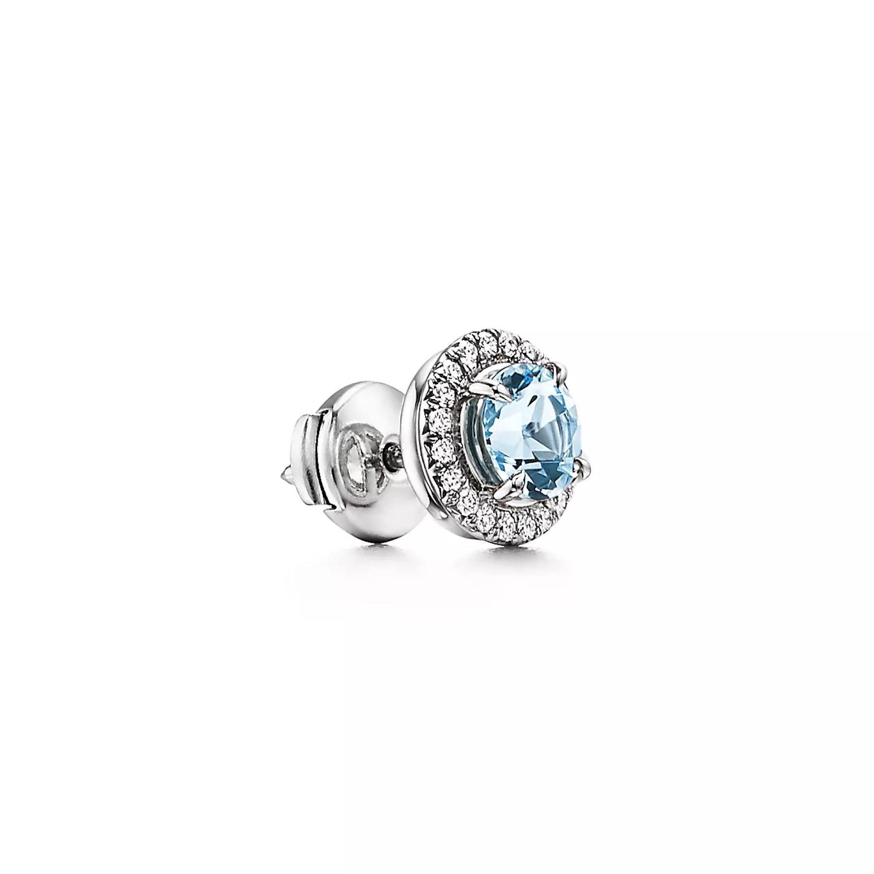 Beautiful earrings by famed designer Tiffany & Co. from the Soleste collection. The earrings are finely crafted in platinum featuring two round aquamarine gemstones in the center each measuring 6 mm. The aquamarine gemstones are each surrounded by a