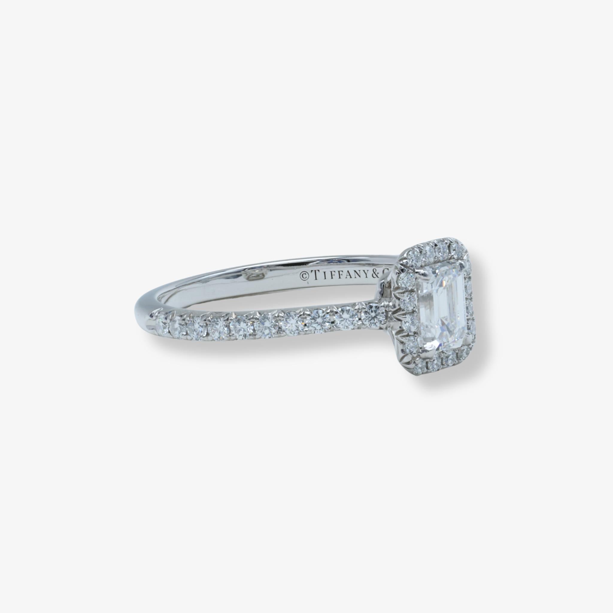 Élégante bague de fiançailles Tiffany Soleste avec un diamant central de 0,43ct de taille émeraude, serti en halo, et un anneau en platine pavé.

-

La collection Tiffany & Co. La bague de fiançailles Soleste® Emerald Cut Diamond est une expression