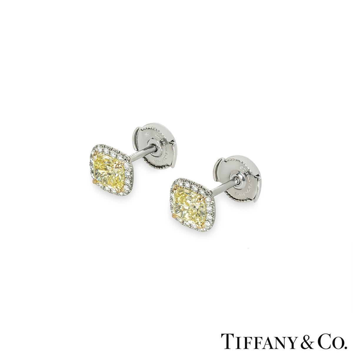 A magnificent pair of platinum diamond earrings from the Soleste collection by Tiffany & Co. Each earring is set with a cushion cut fancy intense yellow diamond, complemented by a halo of pave set diamonds. The first diamond weighs 0.75ct, fancy