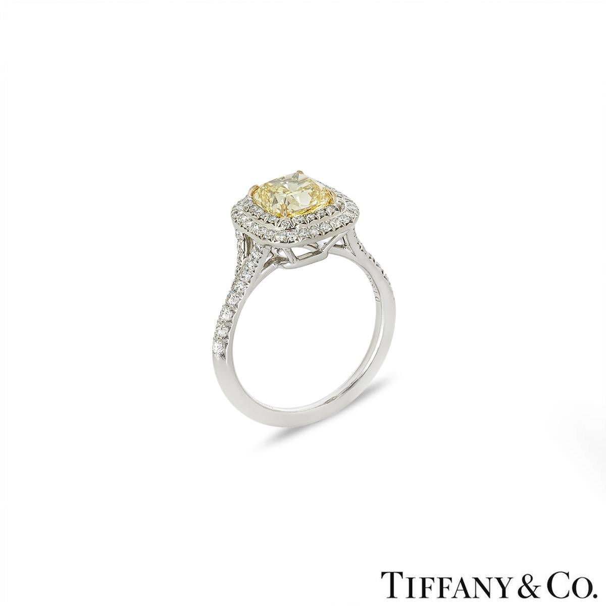 A stunning diamond ring in platinum from the Soleste collection by Tiffany & Co. The ring is set to the centre with a 1.63ct cushion cut fancy intense yellow diamond, with VS1 clarity. Complementing the centre diamond is a double halo and a split