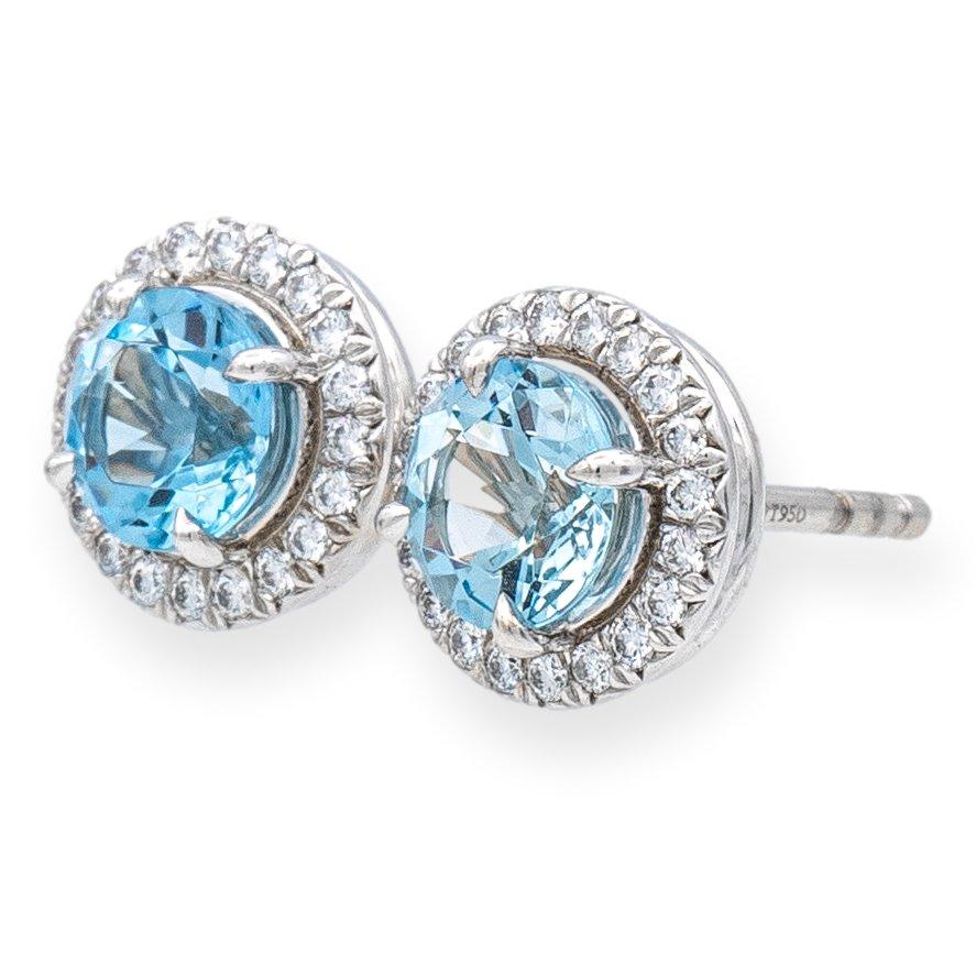 Tiffany & Co. stud earrings from the Soleste collection finely crafted in platinum featuring two round aquamarine centers measuring 6mm each surrounded by a halo of round brilliant bead set cut diamonds weighing 0.40 carats total weight