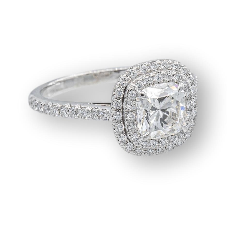 Tiffany & Co. custom made Soleste engagement ring with a 1.19 ct cushion diamond center , I Color, VS2 clarity finely crafted in platinum, accented by a double row halo design with round brilliant cut bead set diamonds weighing 0.36 carats