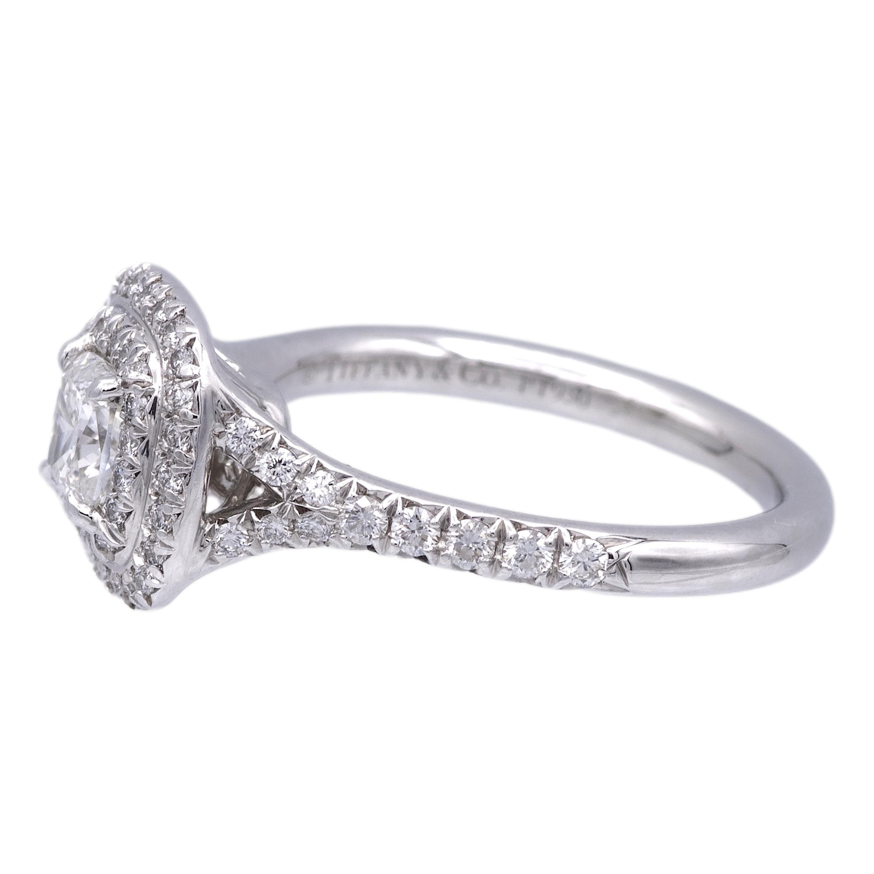 Tiffany & Co. engagement ring from the Soleste collection featuring a .47 ct cushion center , F Color, VS1 clarity finely crafted in platinum, accented by a double row halo and split shank design with round brilliant cut bead set diamonds weighing
