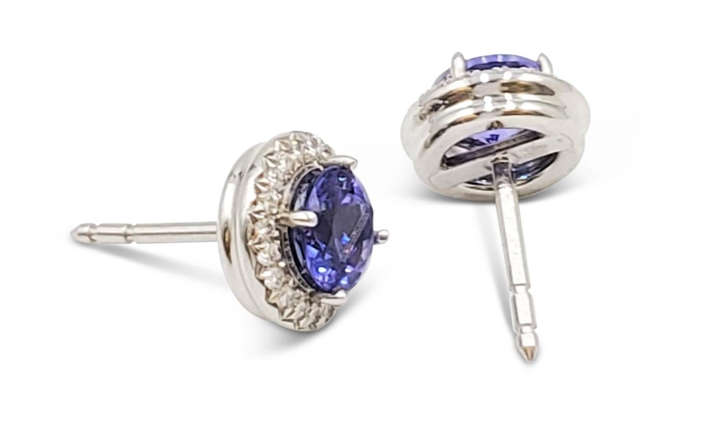Authentic Tiffany & Co. 'Soleste' earrings each center on a round tanzanite stone (approx. 1.40cttw) surrounded by high quality round brilliant cut diamonds (approx 0.19cttw). Signed Tiffany & Co., PT950, No. 6557220. The earrings are presented with
