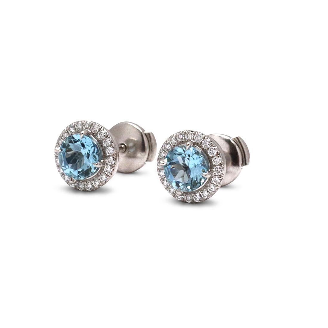 Authentic Tiffany & Co. 'Soleste' earrings each center on a 6mm round aquamarine stone (approx. 1.40cttw) surrounded by high quality round brilliant cut diamonds (approx .40cttw). Signed Tiffany & Co., PT950. The earrings are not presented with