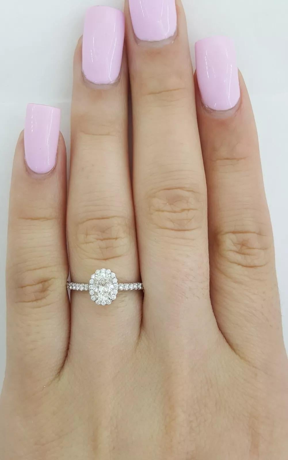 Tiffany & Co. Soleste Platinum Halo Engagement Ring featuring a 0.67 ctw Oval Brilliant Cut Diamond.

This elegant ring weighs 2.6 grams, is a size 5, and measures 7.5mm wide. At its center is a 0.45 ct Natural Oval Brilliant Cut diamond, graded H