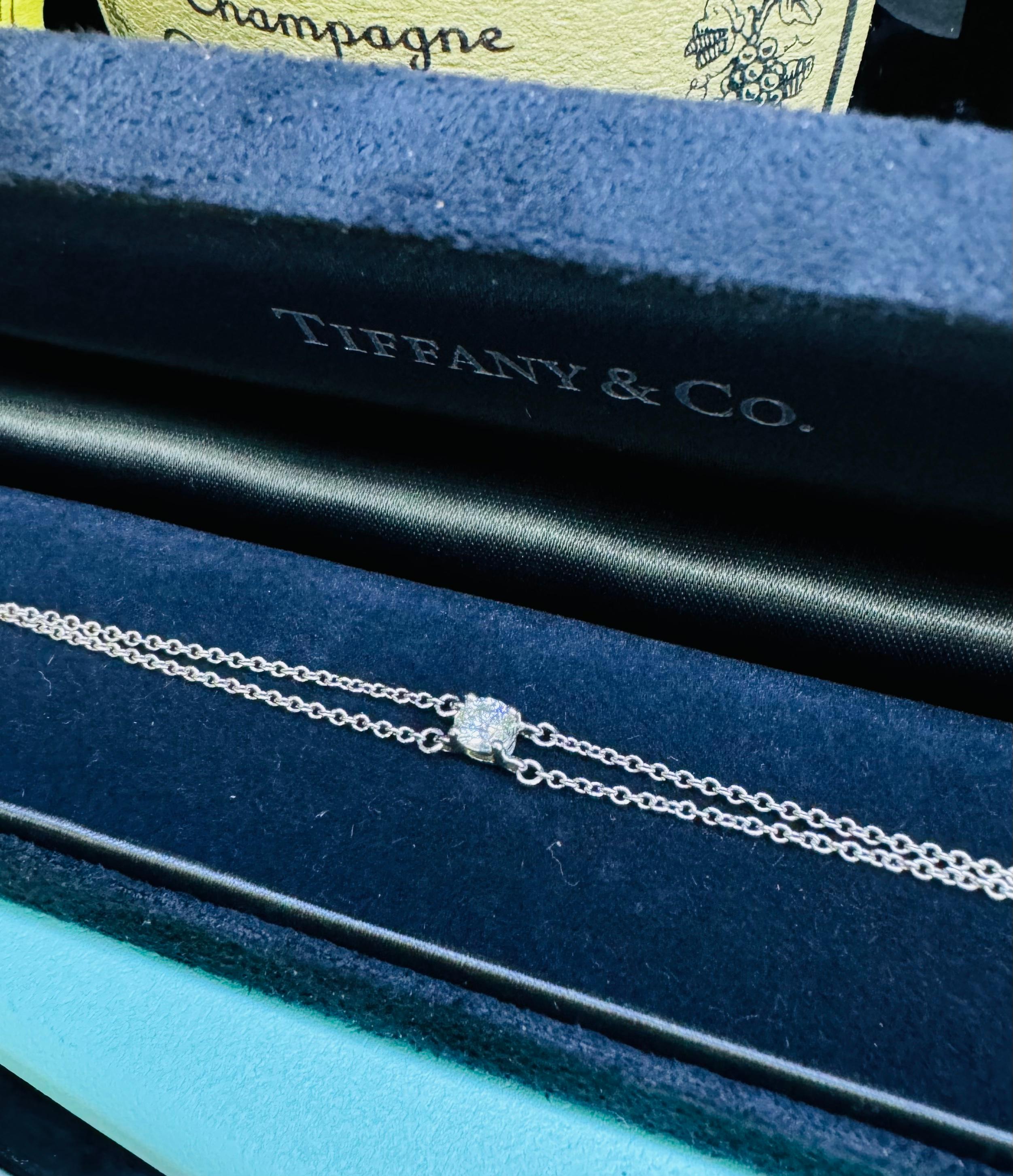 Elegant design crafted in platinum by famed designer Tiffany & Co. The bracelet highlights a double stranded design that leads up to one earth mined natural round brilliant cut diamond weighing 0.17 carat and displaying G color and VVS clarity.  The
