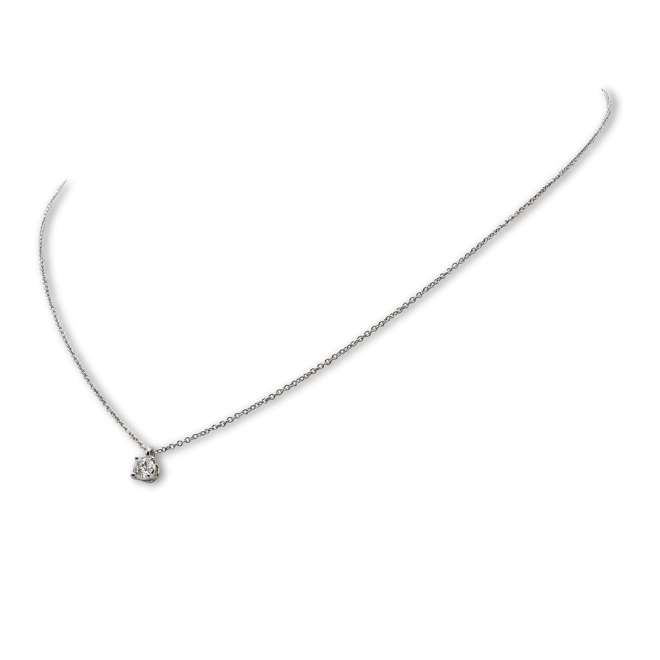 Authentic Tiffany & Co. Necklace crafted in platinum and featuring a round brilliant cut solitaire diamond pendant weighing approximately 0.26 ct, F-G color, VS clarity. The delicate platinum chain measures 16 inches in length. Signed Tiffany & Co,