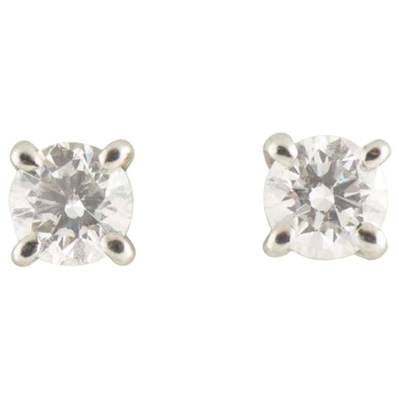 A traditional pair of diamond platinum Tiffany & Co. stud earrings. Each earring is set with a round brilliant cut diamond in a 4 claw setting with a total approximate weight of 0.34ct, G colour and VS in clarity. The earrings feature a post and
