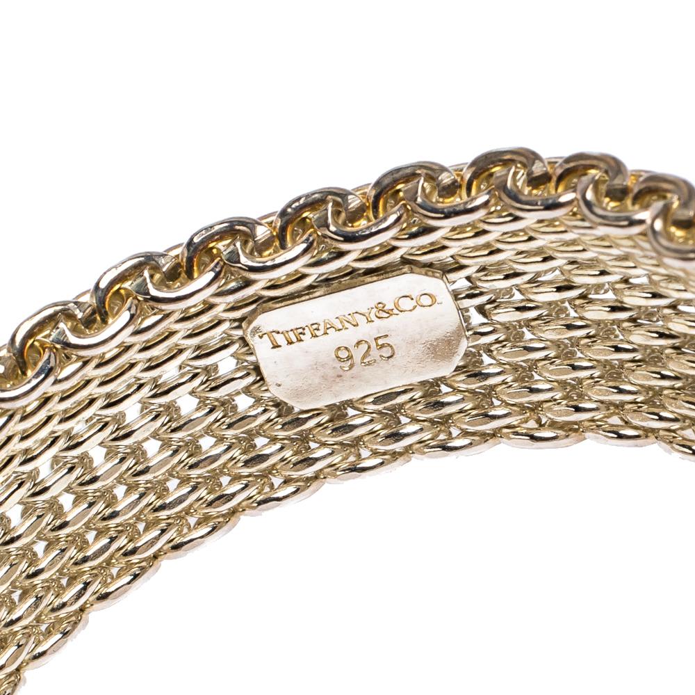 Tiffany and Co. bring forth this exquisite bracelet to pair with your evening ensembles for a luxuriously graceful look . Elegantly crafted into a mesh design, this link bracelet exudes an aura of sophistication with its glowing silver construction.