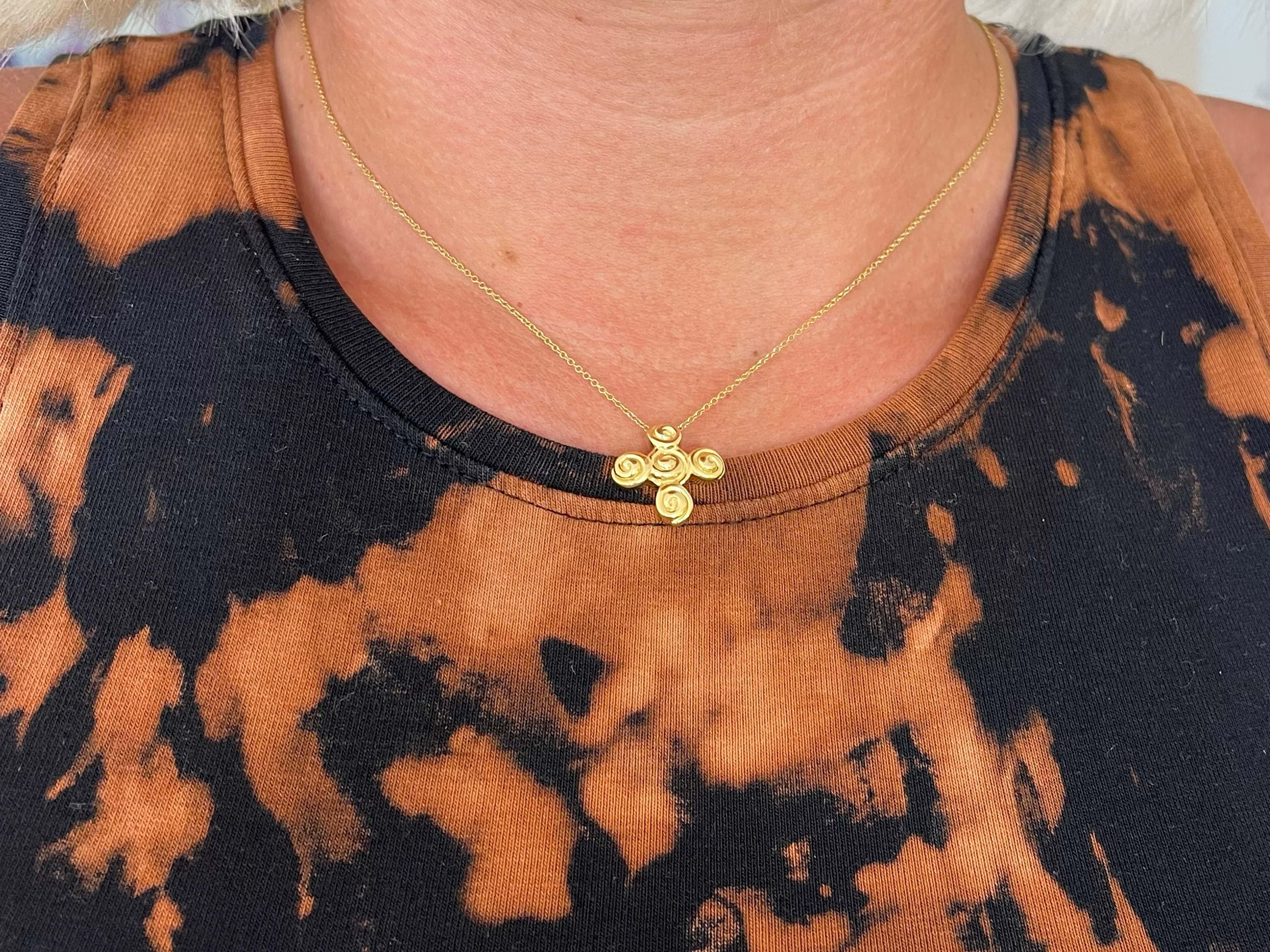 This pendant and chain is richly crafted in 18k yellow gold. The pendant measures 16.9 mm x 16.7 mm and comes on a 16 inch Tiffany & Co. Rolo link chain with a spring ring. The pendant is hallmarked 