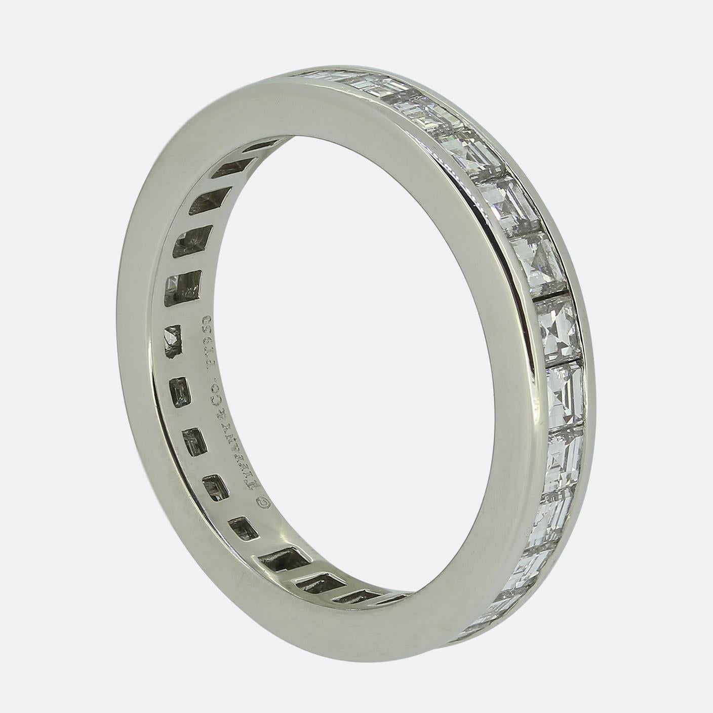 Here we have a diamond eternity ring from the world renowned jewellery designer, Tiffany & Co. The band has been crafted from platinum and features 28 bright white square cut diamonds; all of which have been bezel set in single line formation to