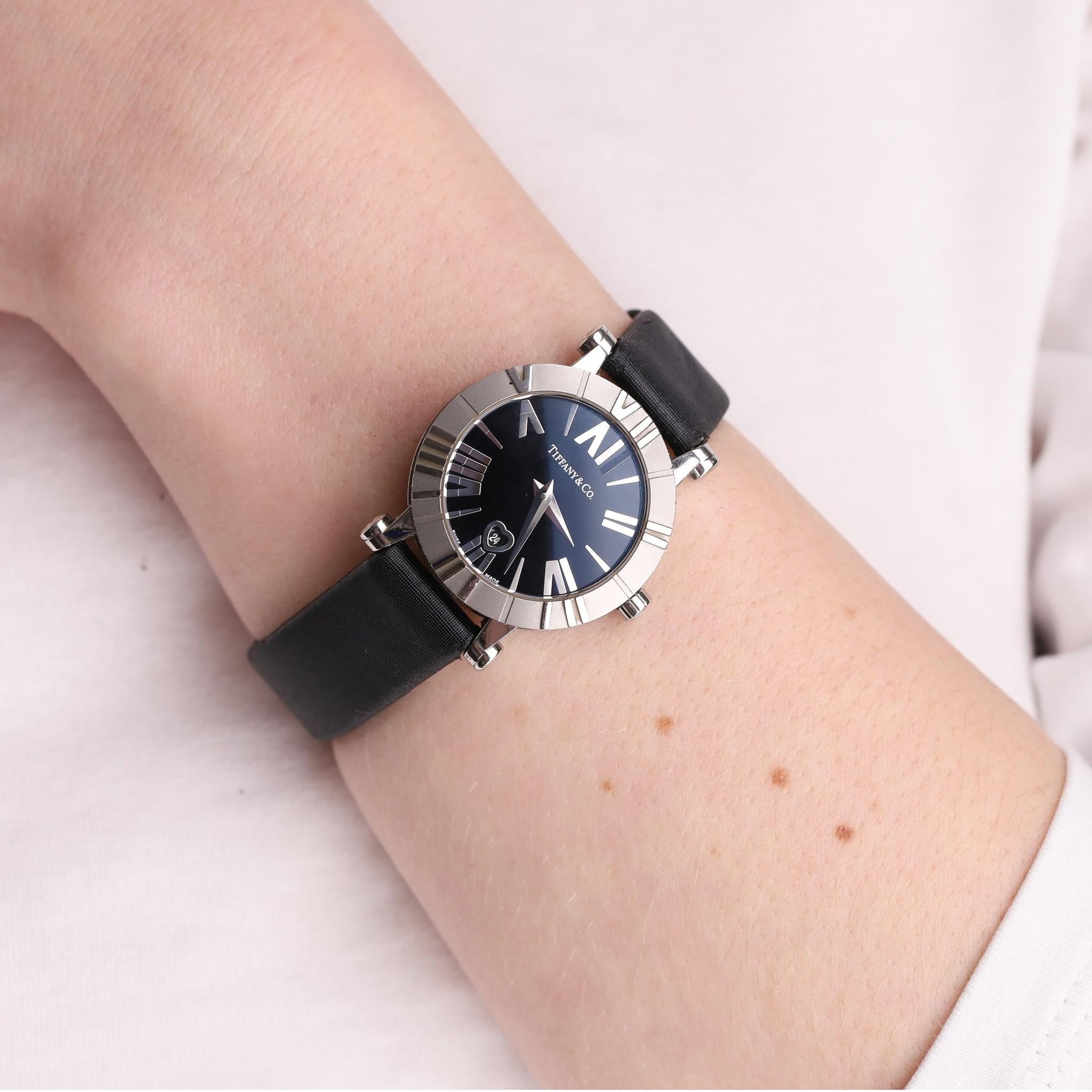 Tiffany & Co. Stainless Steel Automatic Atlas Watch

This beautiful piece is made with stainless steel bezel and black face detailed with silver Roman numerals.

Embellished with heart-shaped date display at 6 o’clock.

Black strap with stainless