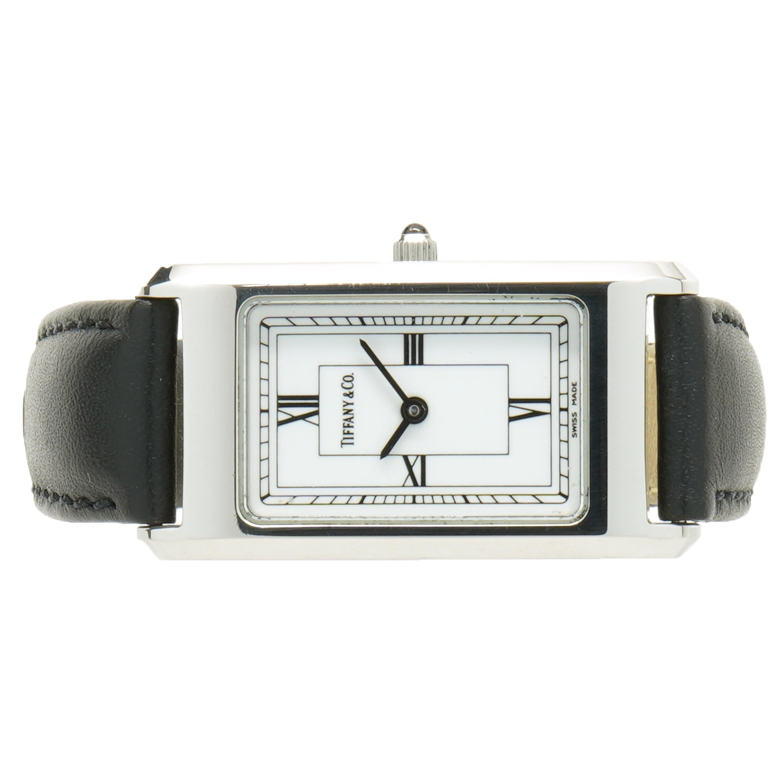 Movement: quartz
Function: hours, minutes
Case: 20mm rectangular stainless steel case, sapphire crystal, push/pull crown, smooth bezel
Band: black leather strap, buckle
Dial: white roman
Serial#: 99XXX
                        
No box or papers
