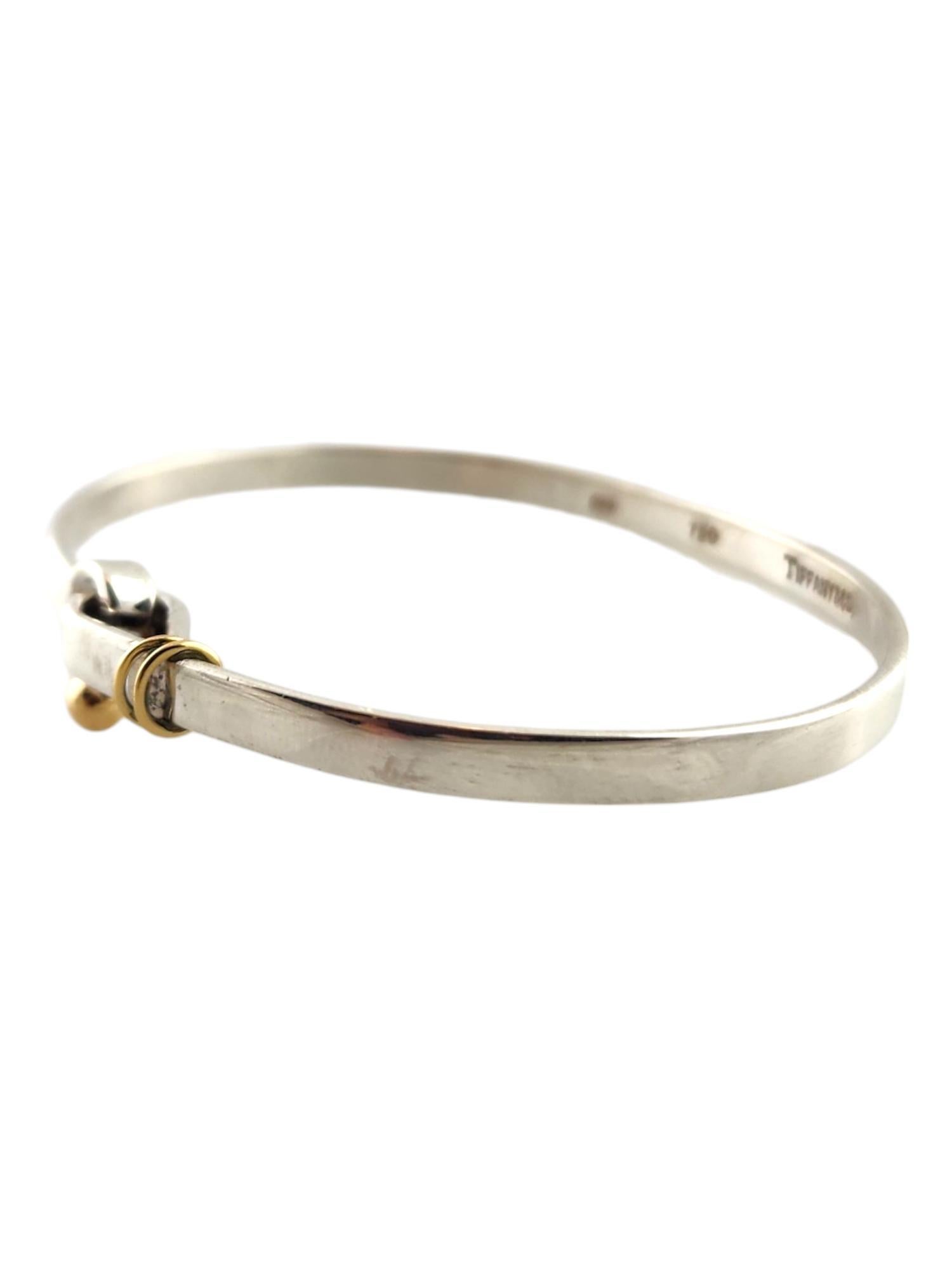 Tiffany & Co Sterling Silver and 18K Yellow Gold Hook and Eye Bangle Bracelet

This gorgeous bangle bracelet by Tiffany & Co was meticulously crafted from sterling silver with beautiful 18K yellow gold detailing!

Size: fits up to  7