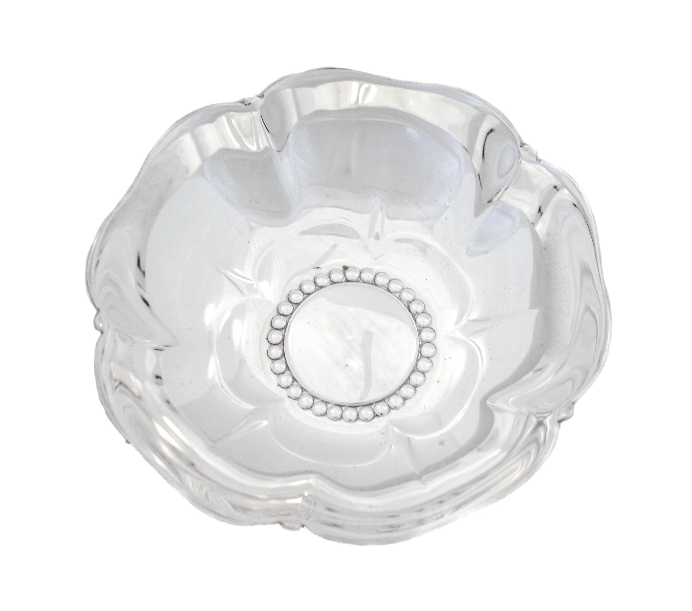 This sterling silver dish by the world renowned Tiffany & Co. is a magnificent example of mid-century silver. The rim is scalloped rim and the center has a beaded pattern. Designed to look like a flower blooming, the sides slope up giving it a