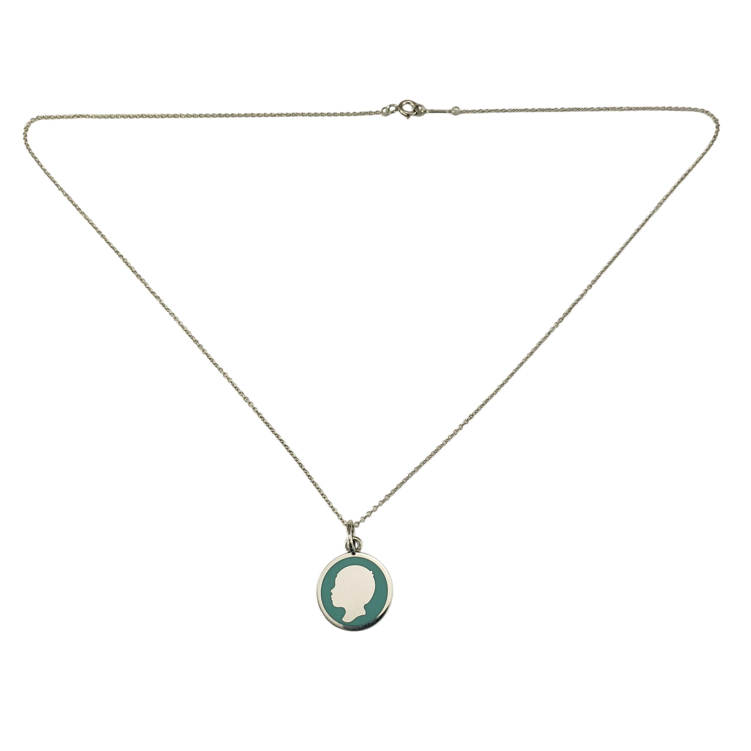 Tiffany & Co. Collana con ciondolo Silhouette di un ragazzo in argento 925 e smalto.

Realizzato in argento sterling, questo ciondolo rotondo presenta un profilo classico su uno sfondo di smalto blu Tiffany. Il ciondolo è sospeso a una sottile