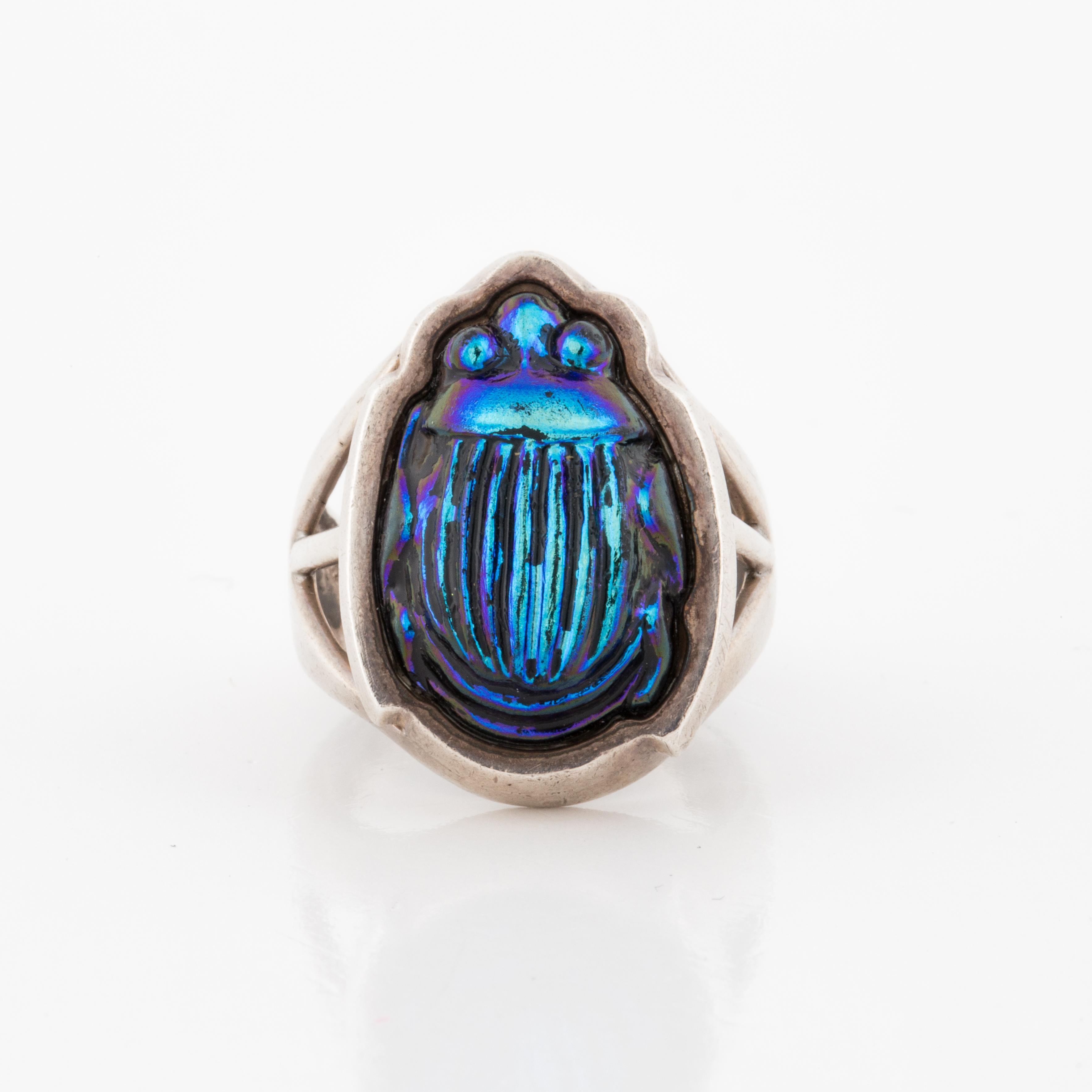 Tiffany & Co. sterling silver ring.  Made from Favrile glass in the form of a scarab.  Ring is currently a size 6-1/2.  Presentation area measures 7/8