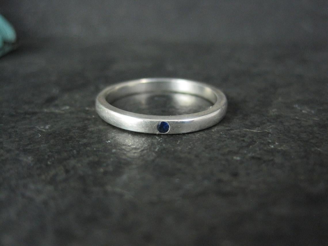 This beautiful band ring is a product of Elsa Peretti for Tiffany & Co.
It is sterling silver with a genuine sapphire.

Measurements: 2.5mm wide
Size: 7 1/2

Marks: Tiffany & Co, 925, Peretti

Condition: Excellent