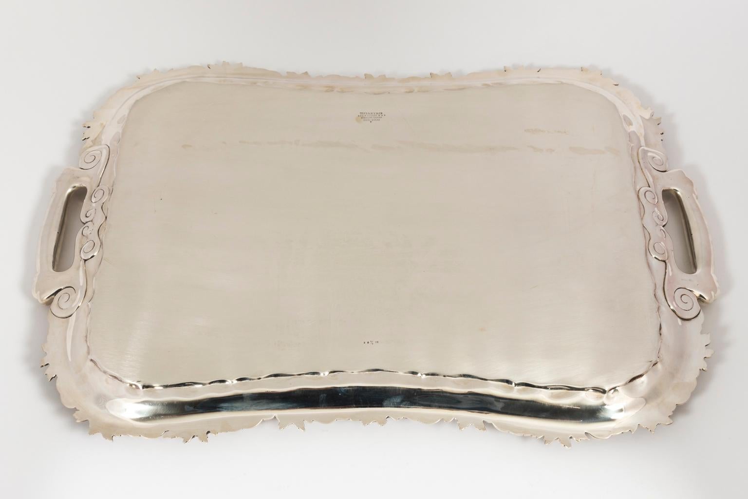 Sterling silver serving tray by Tiffany & Co. with square handles and rose trim. 241 troy ounces, circa 1892-1902.
 