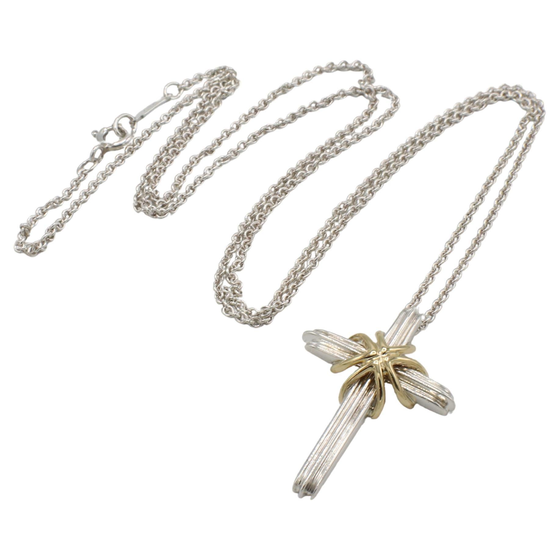 Tiffany & Co. Collana con ciondolo a forma di croce in argento sterling e oro giallo 18 carati 
Metallo: Argento 925 e oro giallo 18 carati
Peso: 7.20 grammi
Croce: 32 x 22 mm 
Catena: 24 pollici
Firmato: ©T&T. 925 750
TD 2605-1