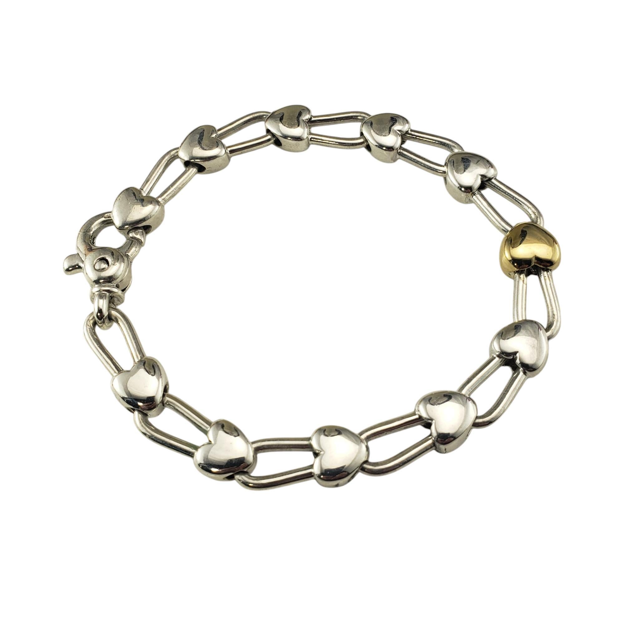 Tiffany & Co. Sterling Silver and 18K Yellow Gold Heart Link Bracelet-

This lovely Tiffany & Co. two-tone heart link bracelet is set in sterling silver with an 18K yellow gold heart at its center. 

Width: 8 mm.

Size: fits up to 7