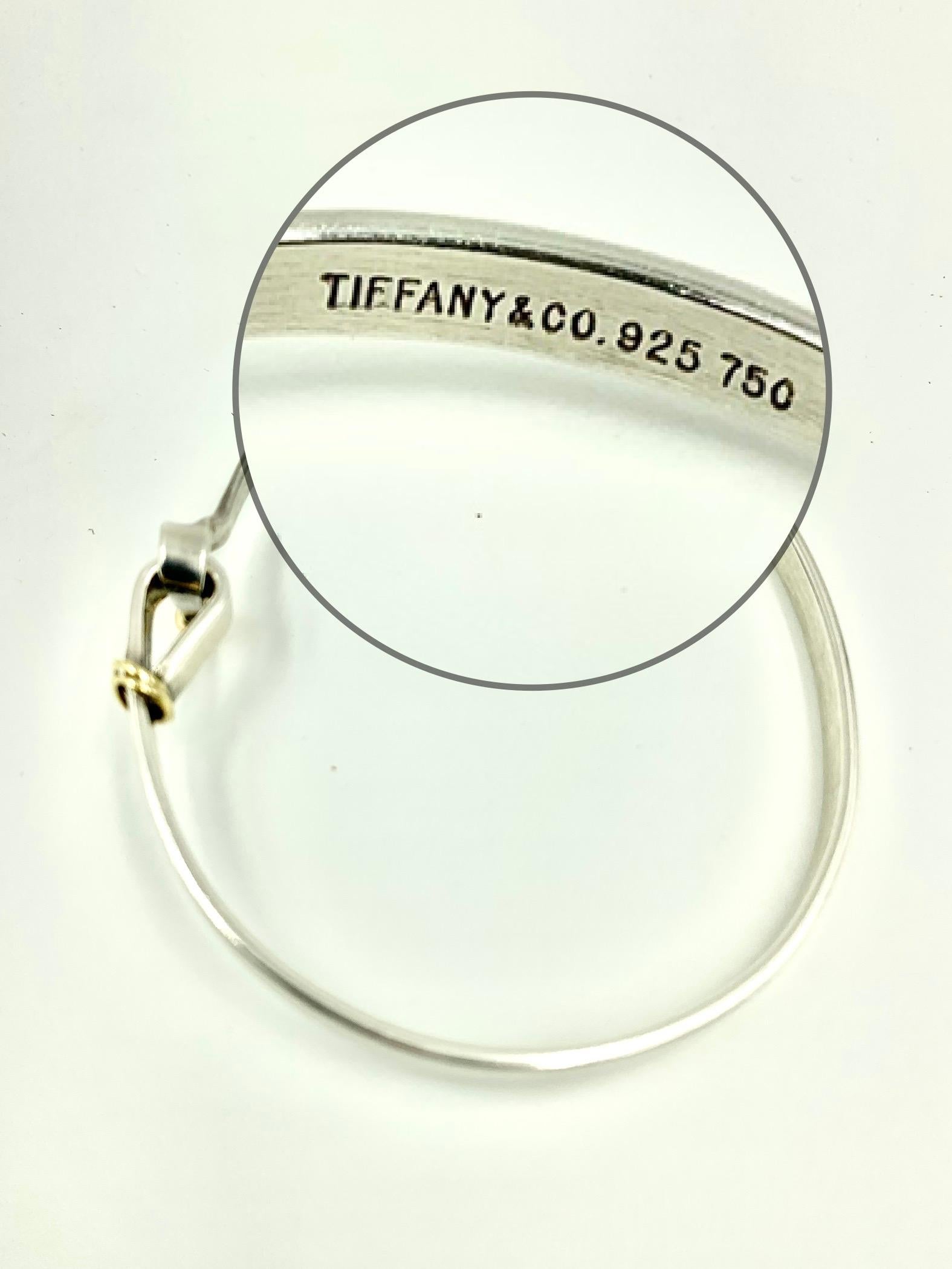Tiffany & Co. sterling silver and 18K yellow gold Hook and Eye bangle bracelet in excellent estate condition.
Marks: Tiffany & Co., 925, 750
Circumference: 7.5 inches
Width of hook: .44 inches
Weight: 12.6 grams
This piece will arrive in the