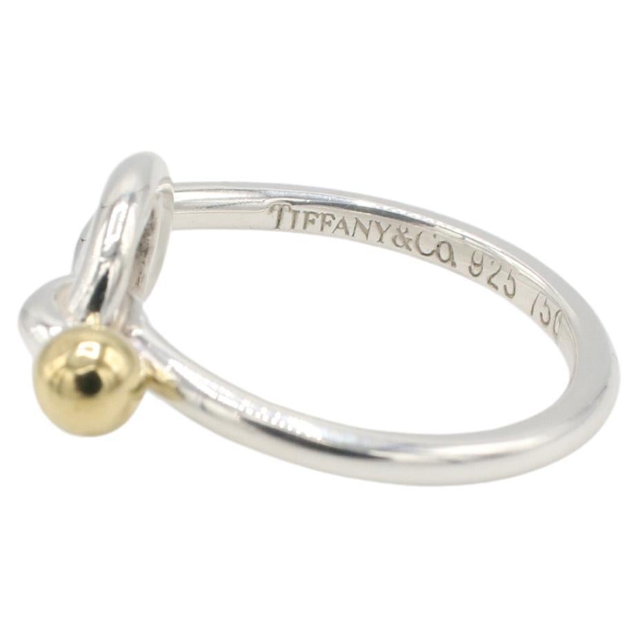 Tiffany & Co. Sterling Silver & 18K Yellow Gold Love Knot Ring 
Metal: Sterling silver & 18k yellow gold
Weight: 2.86 grams
Signed: Tiffany & Co. 925 750
Size: 5 (US)
