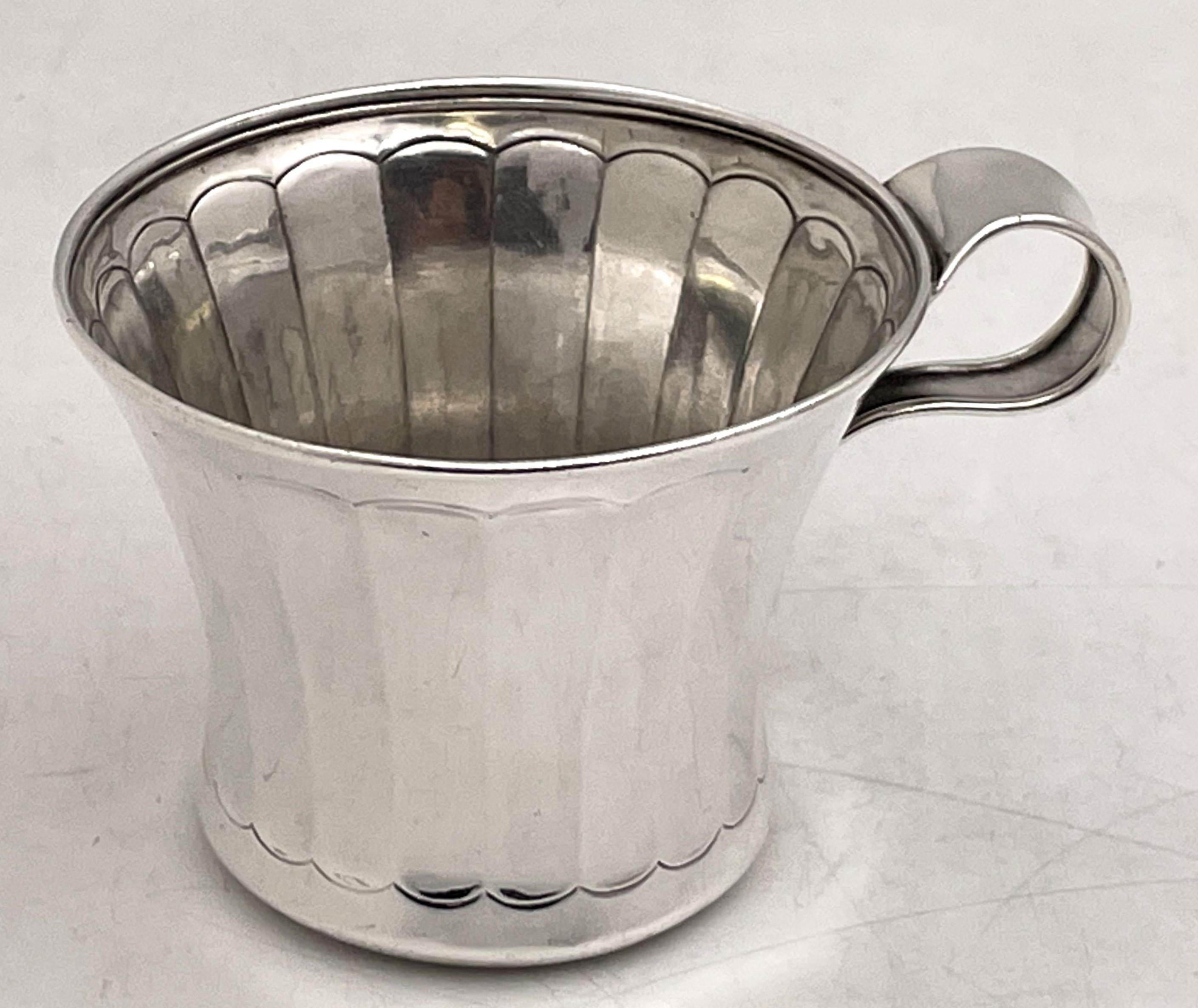 Tiffany & Co. sterling silver child mug in pattern number 17270 from 1908 in Art Deco style with an elegant, geometric design, and with special hand work. It measures 2 2/3'' in height by 3 3/8'' in diameter at the top, weighs 3.8 troy ounces, and