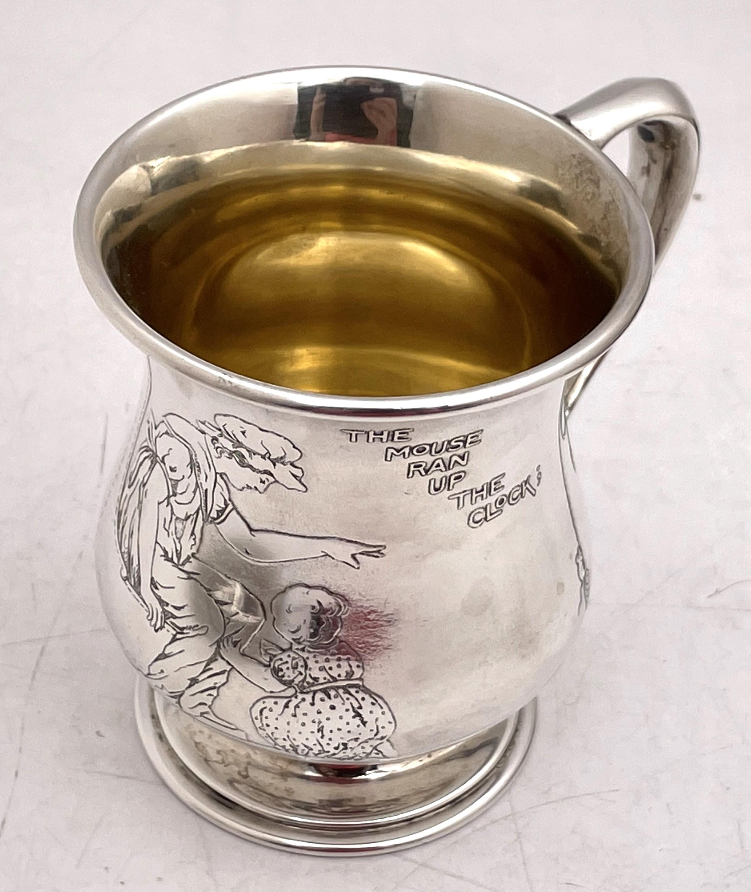 Tiffany & Co. sterling silver child mug, gilt inside, in pattern number 17139 from 1908, showcasing a mother and child, a mouse running up a clock as well as other beautiful motifs. It measures 3 1/2'' in height by 2 7/8'' in diameter at the top (3