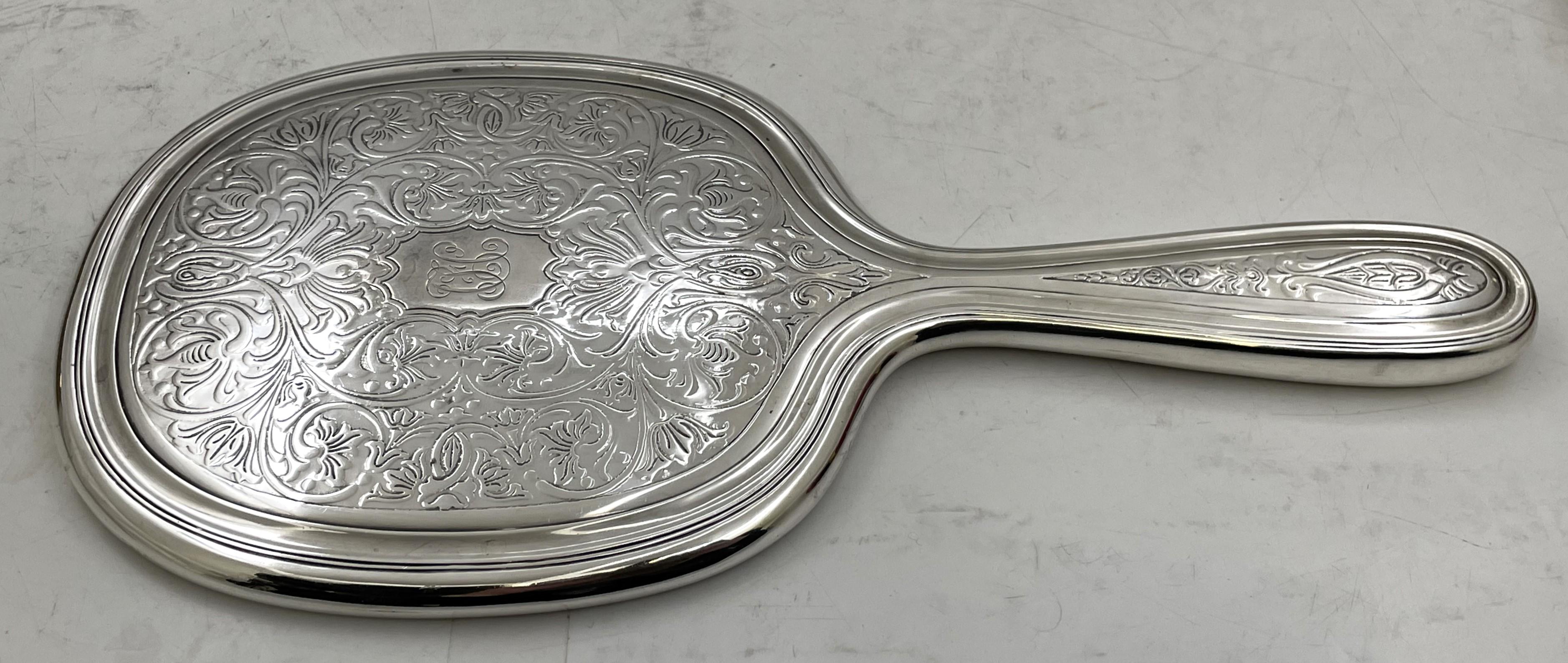 Set da toeletta e vanità in argento sterling di Tiffany & Co. del 1908, in stile Art Nouveau, con motivi naturali stilizzati e fluenti, composto da:

uno specchio, che misura 10 3/4'' di lunghezza per 5'' di larghezza per 1/2'' di profondità, con il
