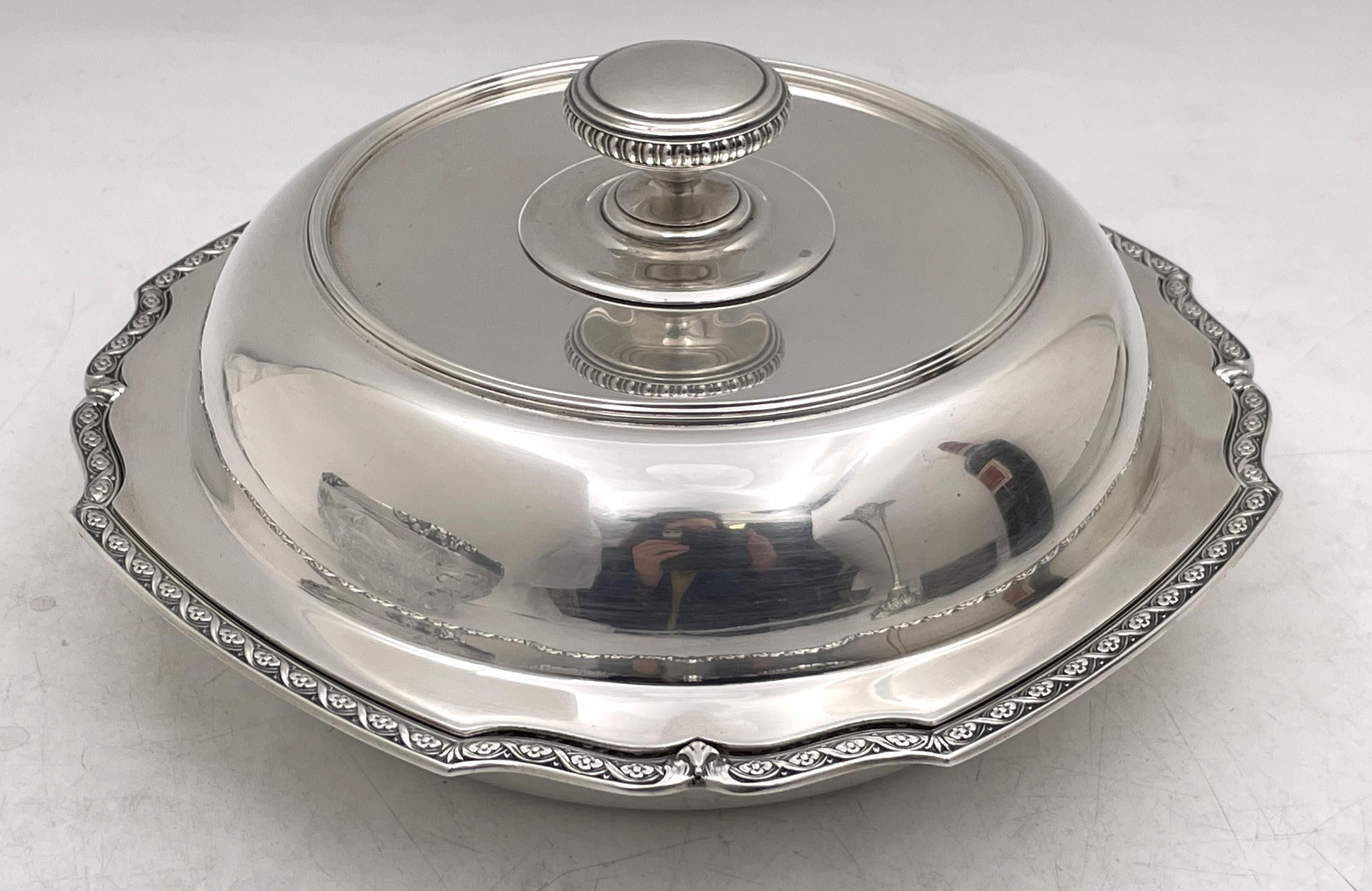 Tiffany & Co. sterling silver covered vegetable dish in pattern number 20682 from 1926 in Art Deco style with an elegant, geometric design and adorned with floral motifs around the rim. It measures 9 1/3'' in diameter by 5'' in height, weighs 37.5