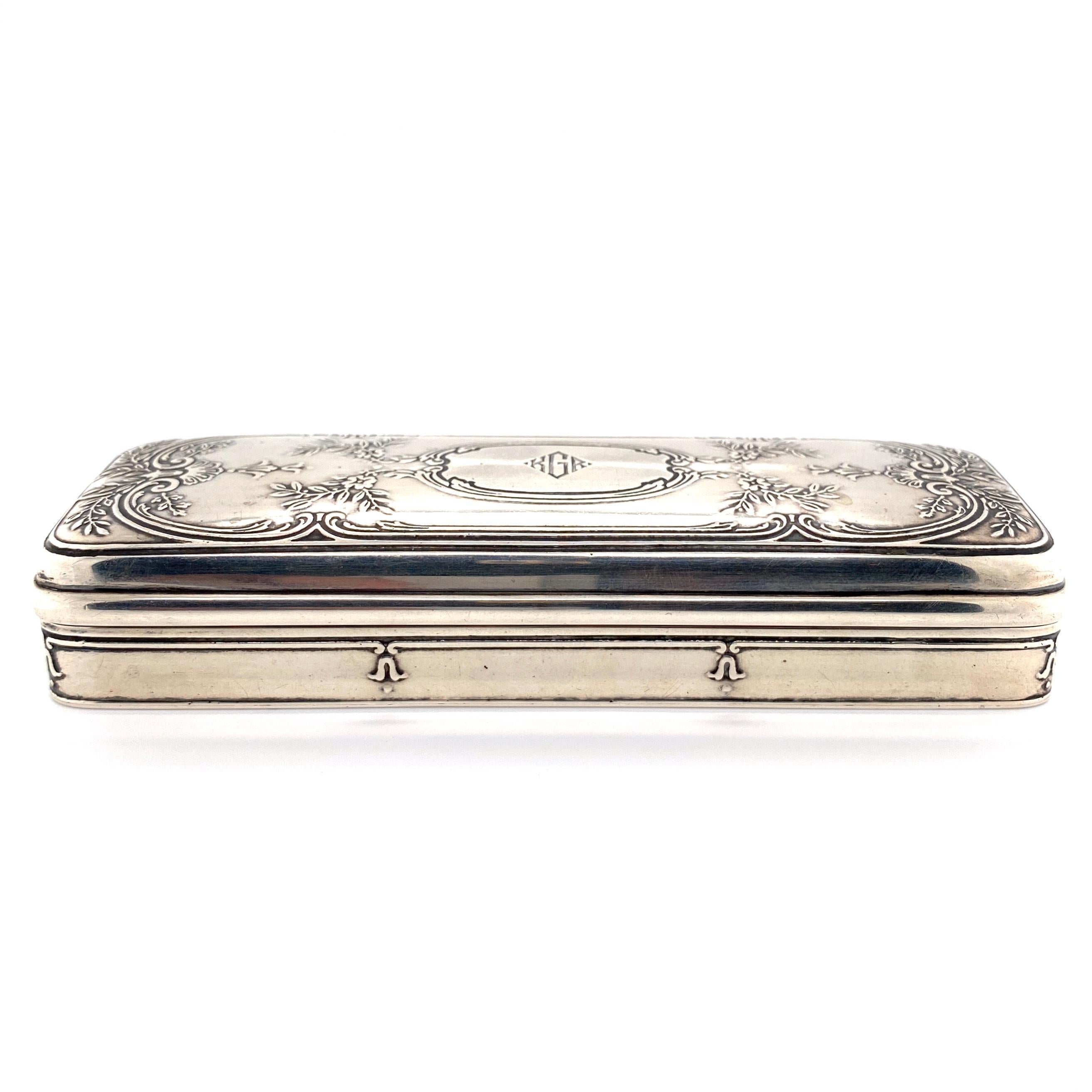 Iconic Tiffany & Co. sterling silver 925 box. Beautifully hand engraved design and detailing on top and sides and center with initialed monogram: KGR. Approx. dimensions: 5.50” l x 1.78” w x 1.03” h. Circa: 1900. Base stamped: TIFFANY & CO 7969 L