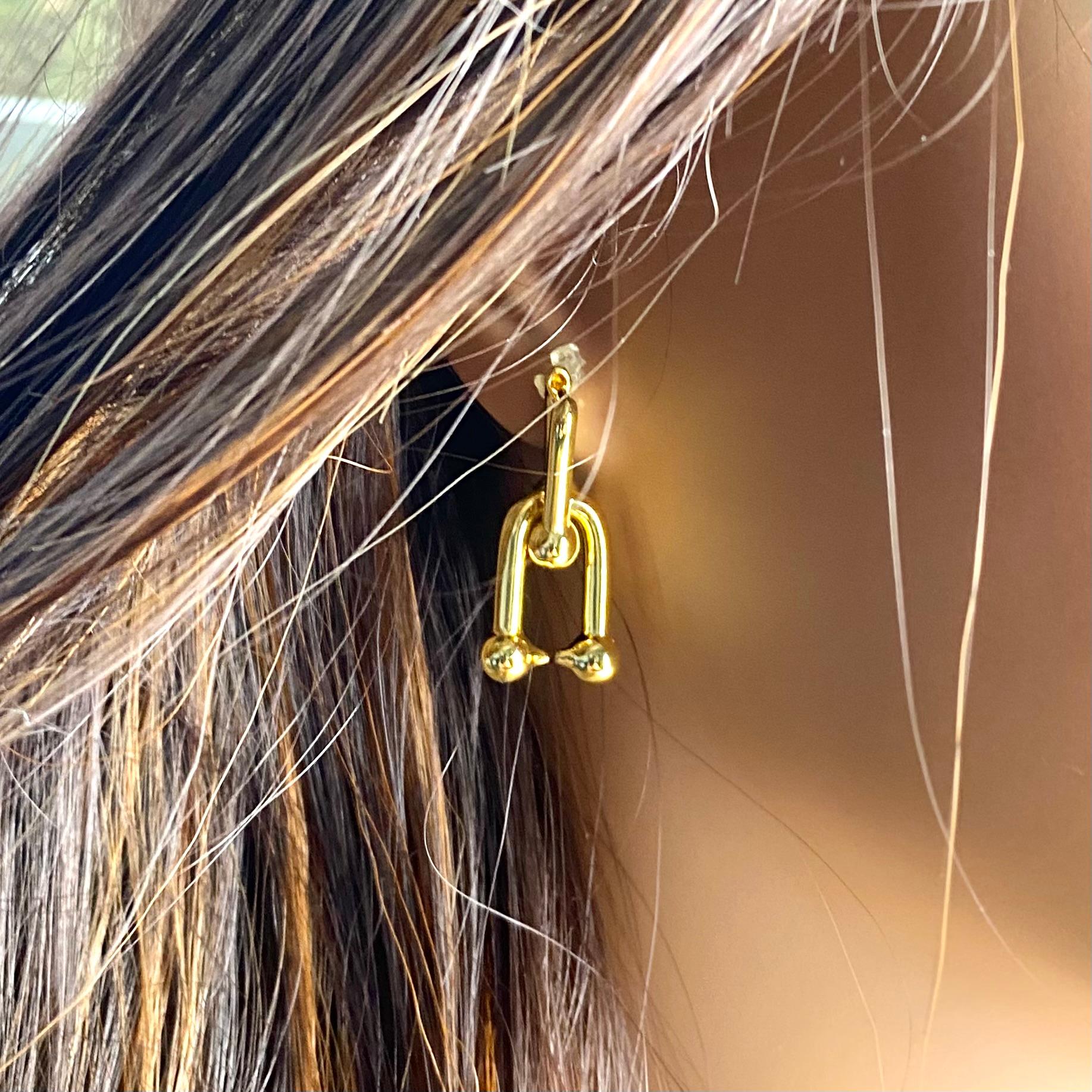 A Contemporary Take on Timeless Tiffany Elegance

Add a touch of everyday sophistication to your look with these Tiffany & Co. Sterling Silver U-Ball Hoop Earrings. Carefully crafted from 925 sterling silver and plated with a rich gold tone, each