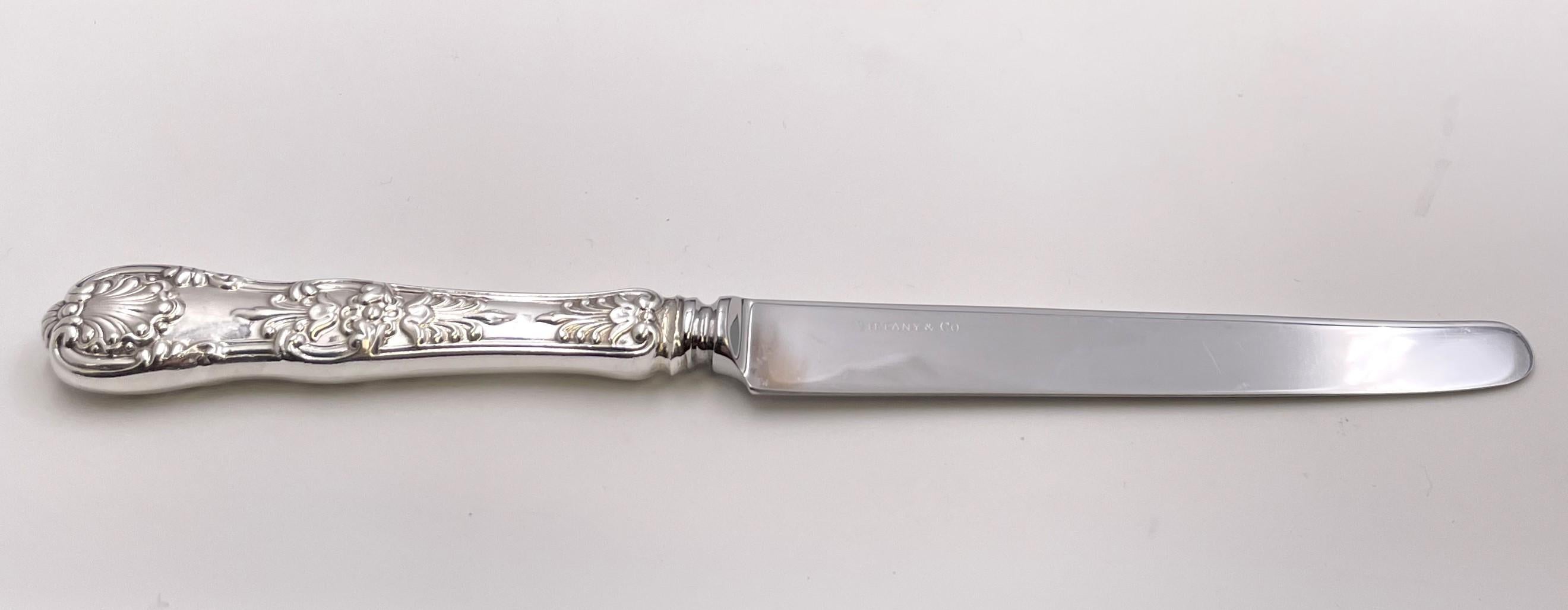 Service de couverts en argent sterling de Tiffany & Co. dans le célèbre modèle English King, orné de coquillages et d'autres motifs, composé de :

8 couteaux de table à lame française d'une longueur de 10 1/2''.
8 couteaux de table mesurant 9 1/4''