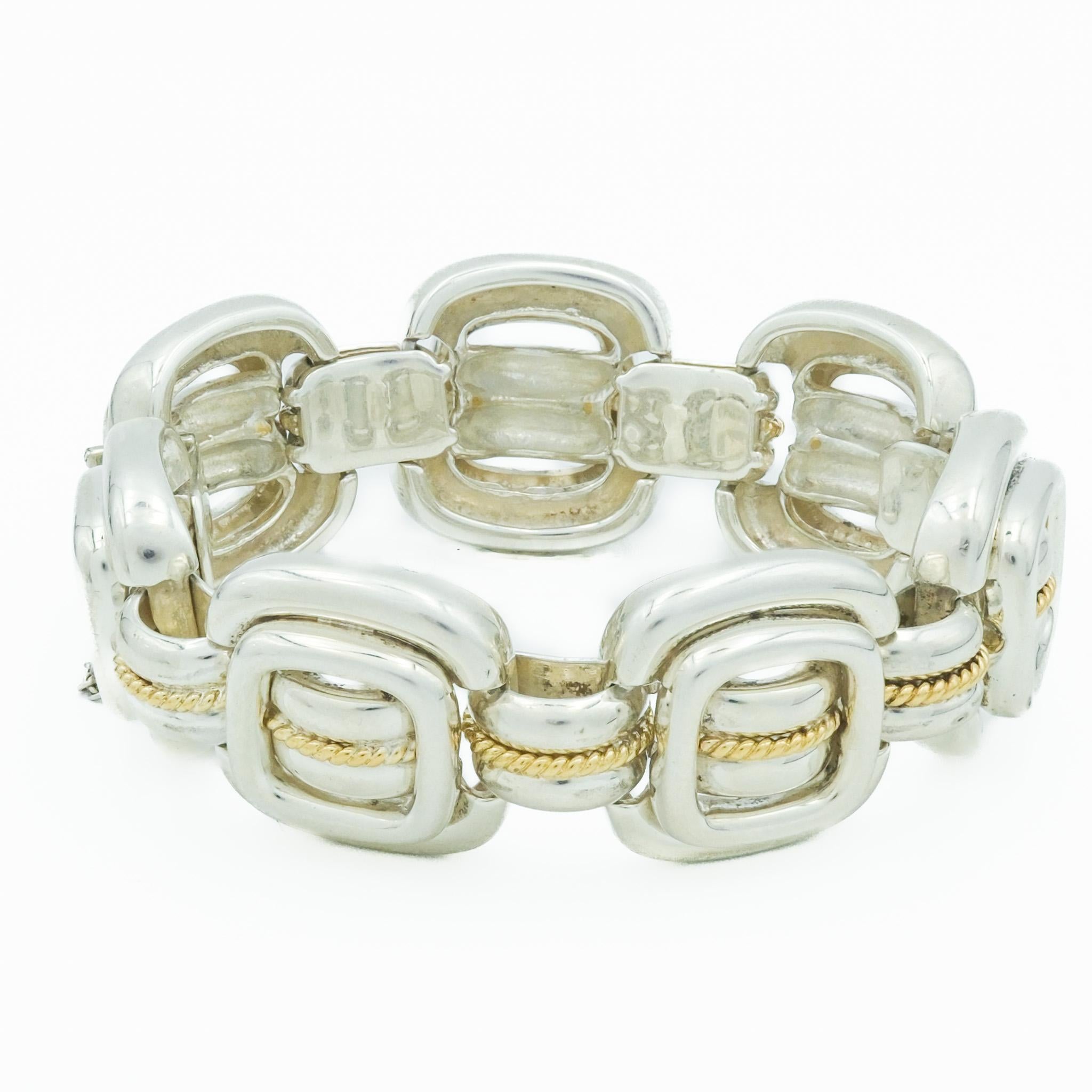 This distinctive sterling silver and gold bracelet from Tiffany & Co., crafted during the 1980s, reflects a period renowned for bold and luxurious jewelry designs. The bracelet features interlocking links that blend polished sterling silver with