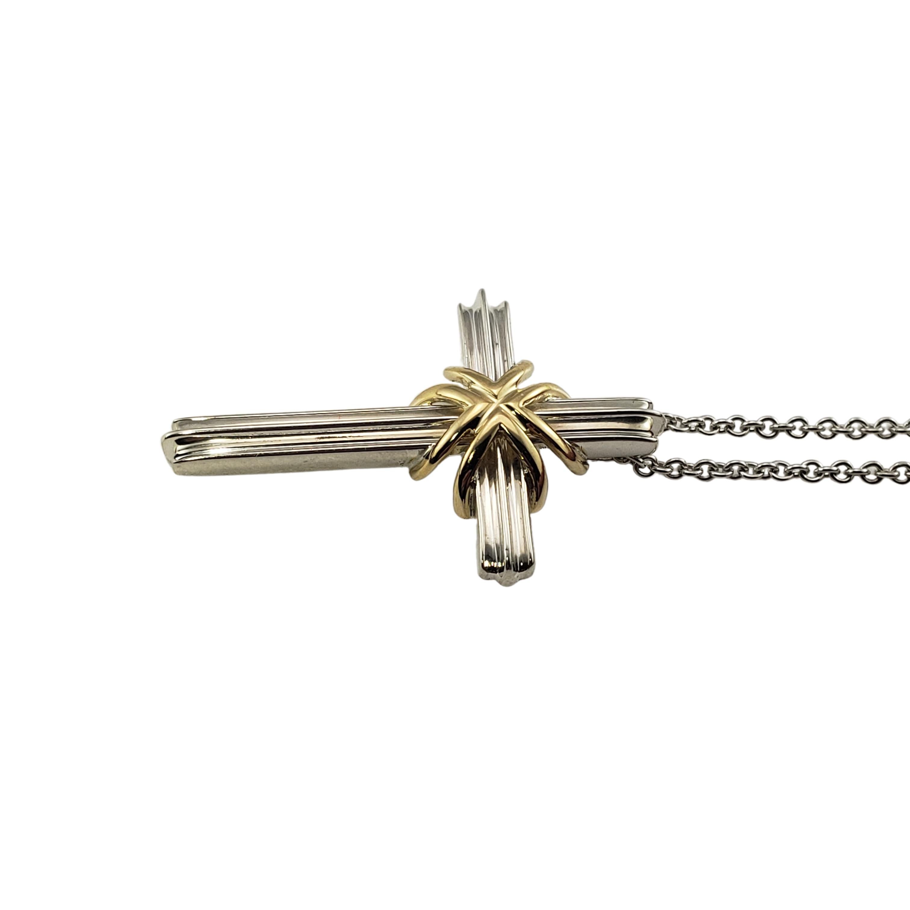 Tiffany & Co. Sterling Silver and 18K yellow Gold Cross Pendant Necklace-

This lovely cross pendant is crafted in beautifully detailed sterling silver and accented with 18K yellow gold.  Suspends from a classic cable chain.

Size:  17.5 inches