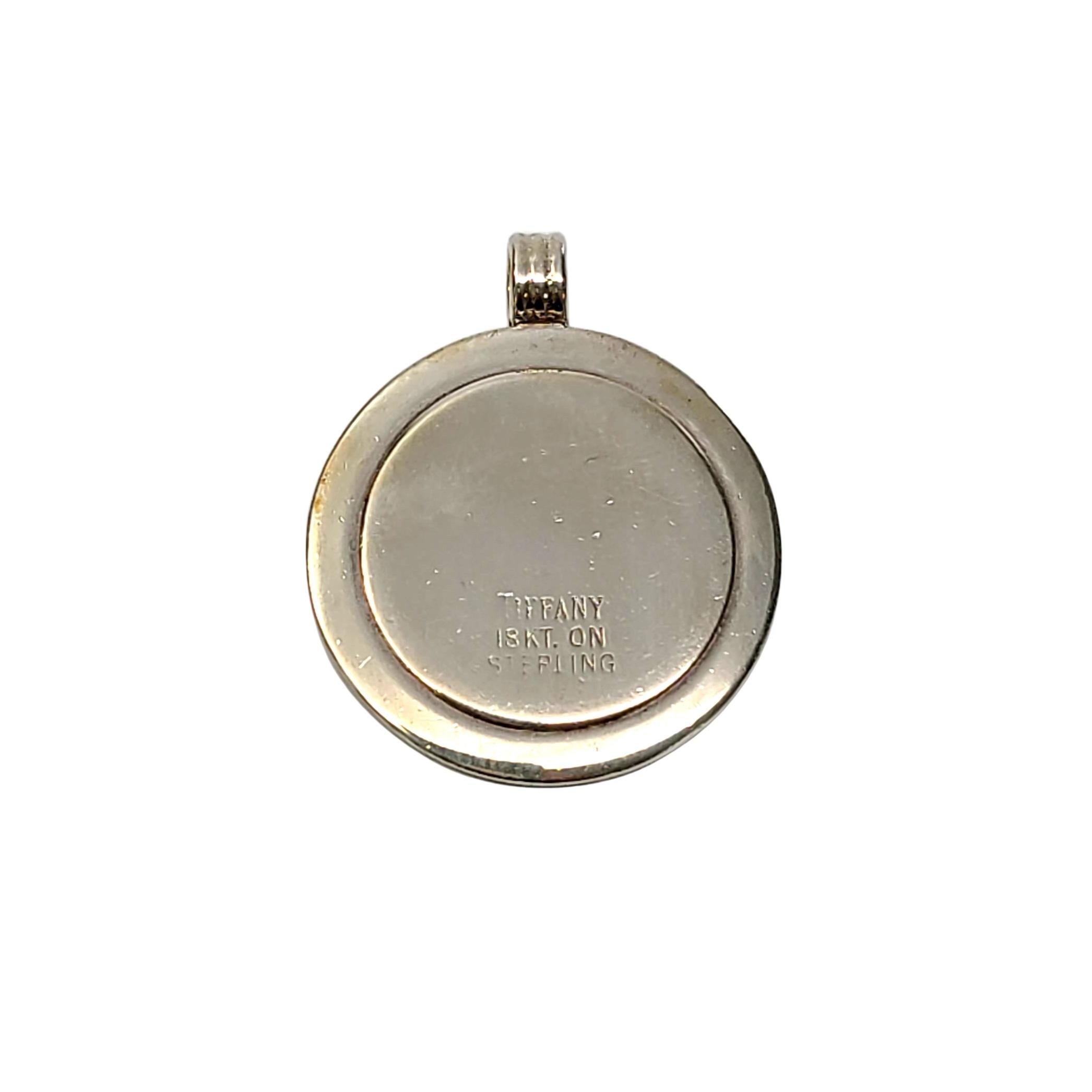 Tiffany & Co sterling silver and gold round disc pendant.

Authentic Tiffany sterling silver disc pendant with 18K yellow gold over sterling silver inner disc. Does not include Tiffany & Co box or pouch.

Measures approx 1 1/8