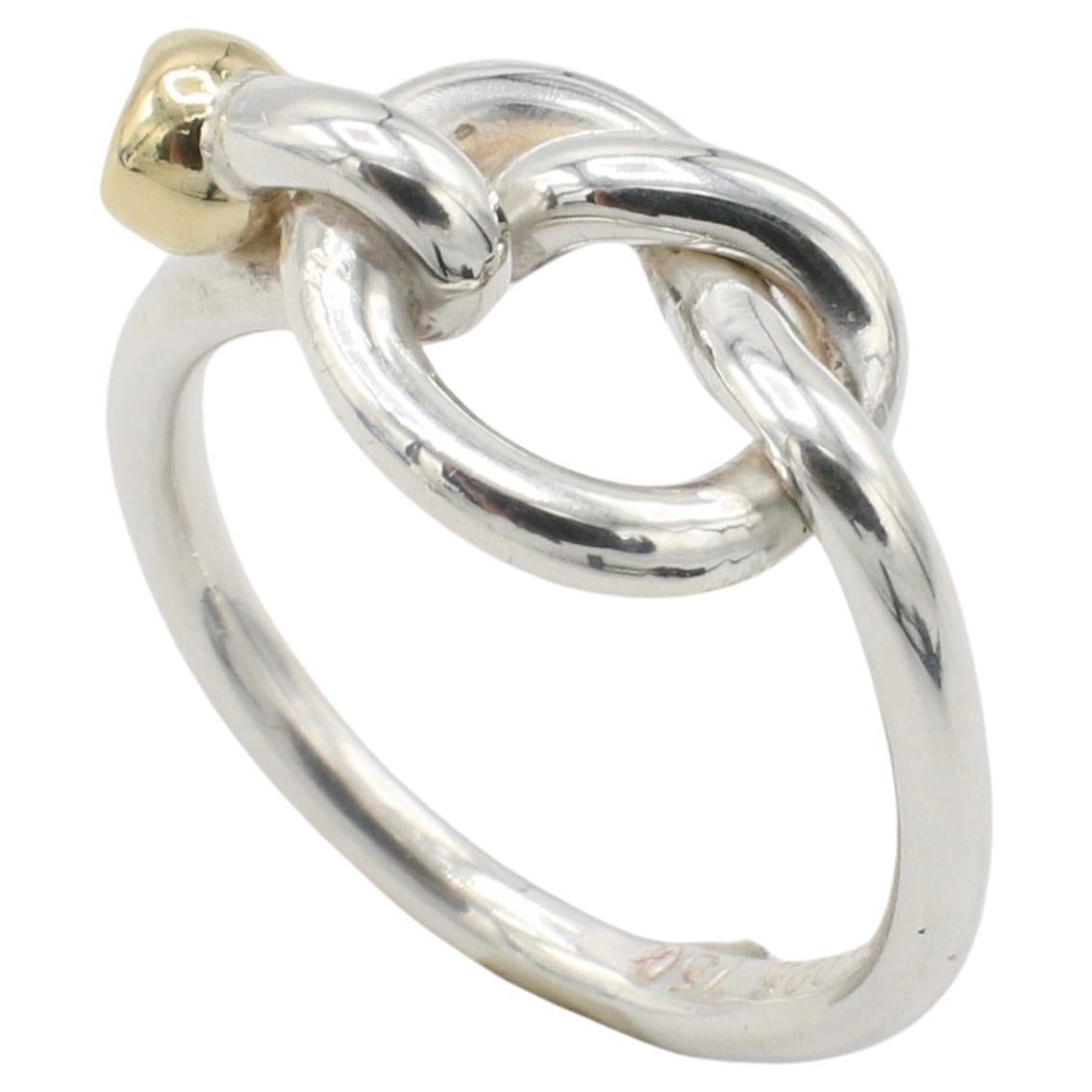 Tiffany & Co. Sterling Silver and 18K Yellow Gold Love Knot Ring
Metal: Sterling silver & 18k yellow gold
Weight: 2.86 grams
Size: 4.5 (US)
Signed: Tiffany & Co. 925 750
Width: 2 - 9.5mm
