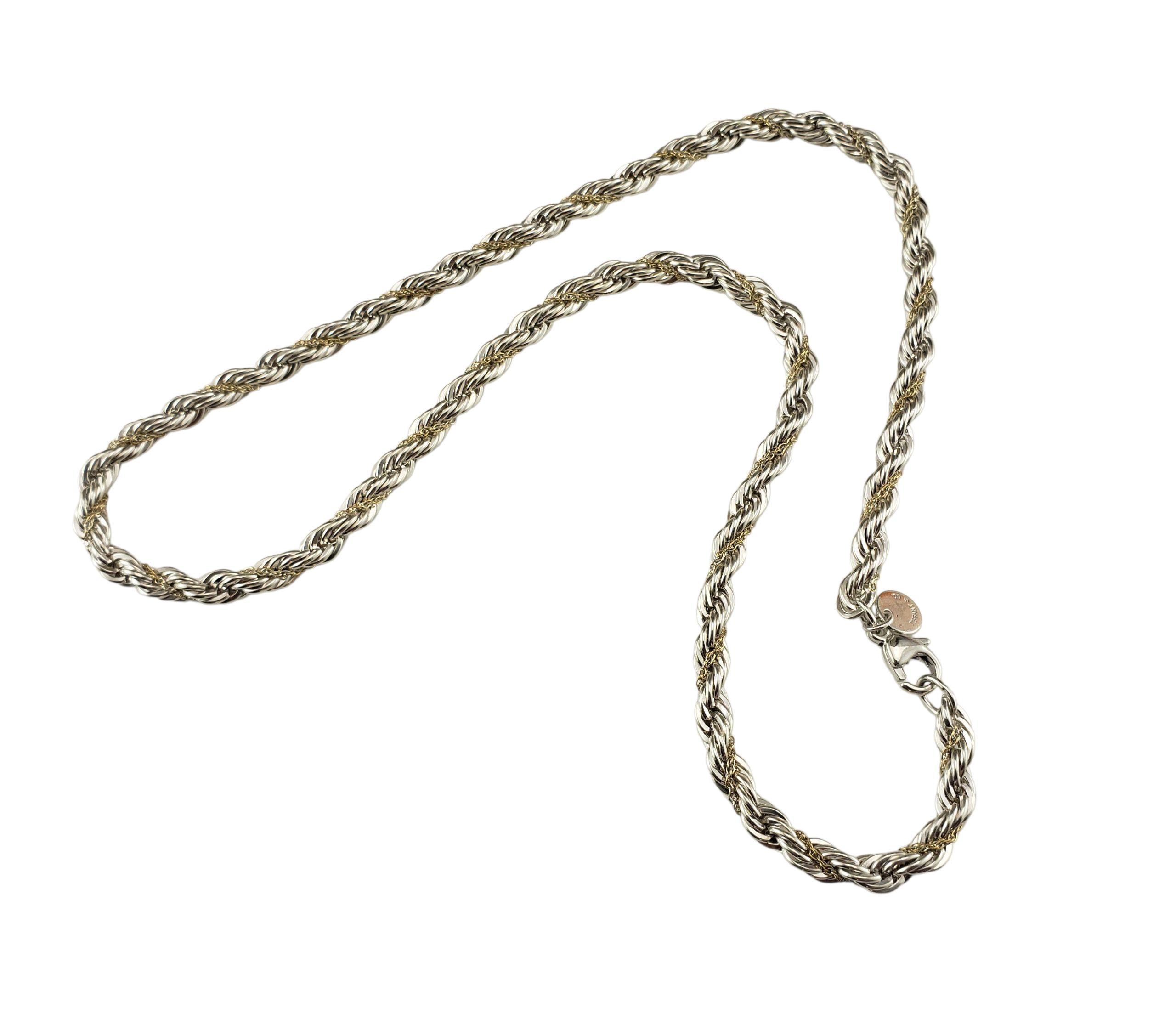 Tiffany & Co. Collana a catena in argento sterling e oro giallo 18 carati.

Questa elegante collana è caratterizzata da maglie intrecciate in argento sterling accentate da delicate fasce in oro giallo 18 carati, che creano il caratteristico stile a