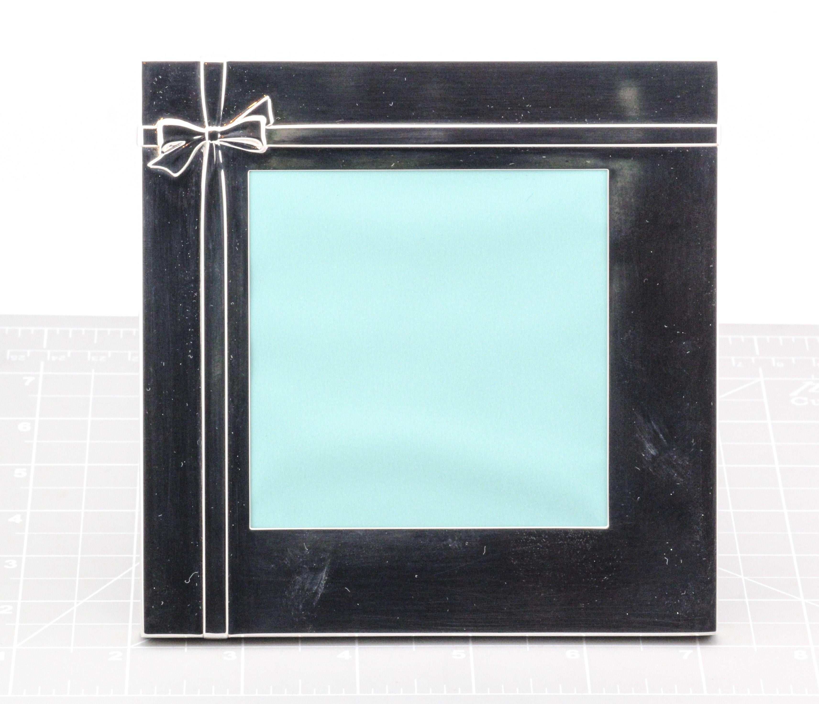 The Tiffany & Co. Sterling Silver and Leather Wrapped Gift Picture Frame is a stunning piece that exemplifies the brand’s timeless elegance and craftsmanship. The frame is meticulously crafted from gleaming sterling silver, which is polished to a