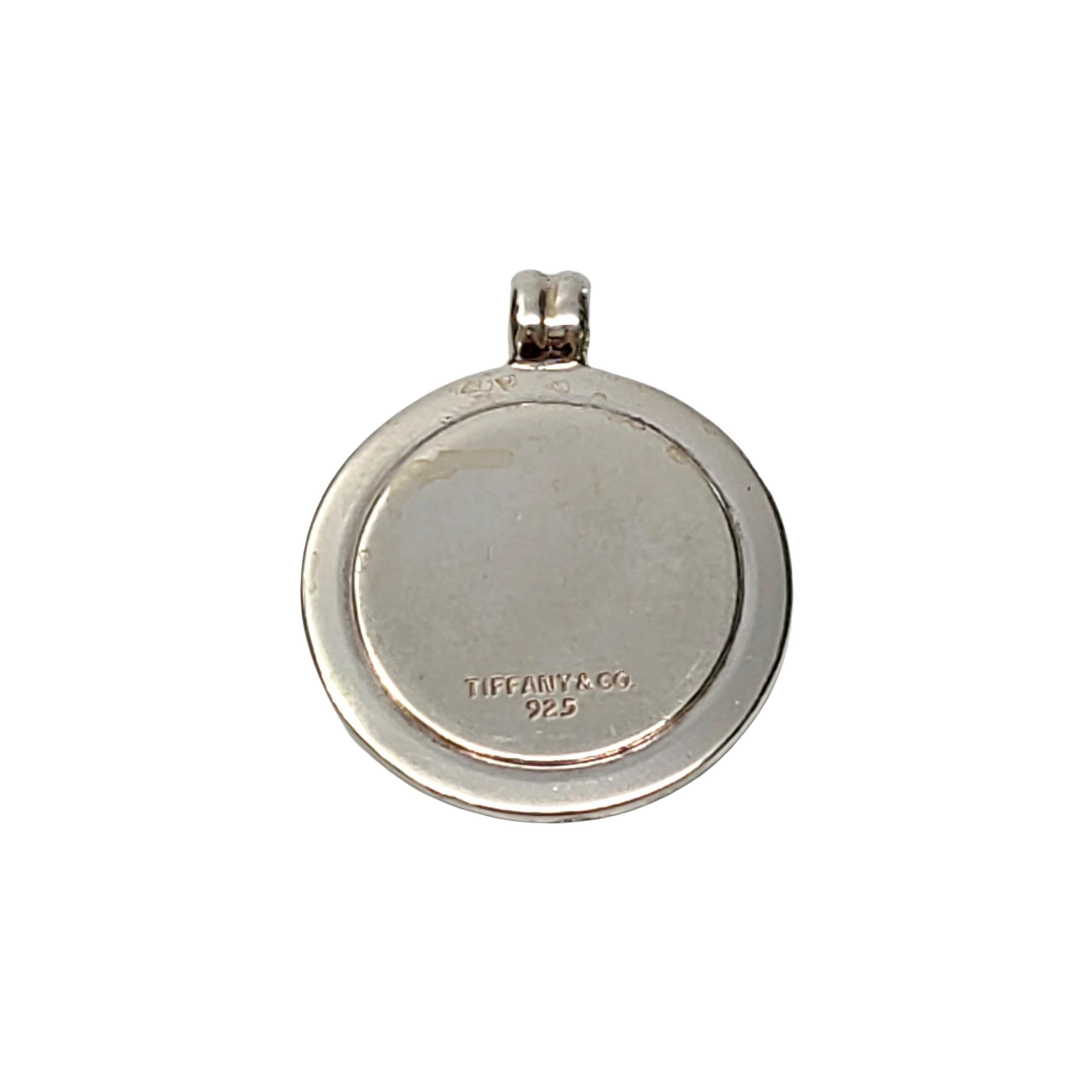 Tiffany & Co sterling silver and gold plated round disc pendant with vintage T&CO logo.

Authentic Tiffany sterling silver disc pendant with gold plated inner disc featuring the vintage T&CO logo. Does not include Tiffany & Co box or