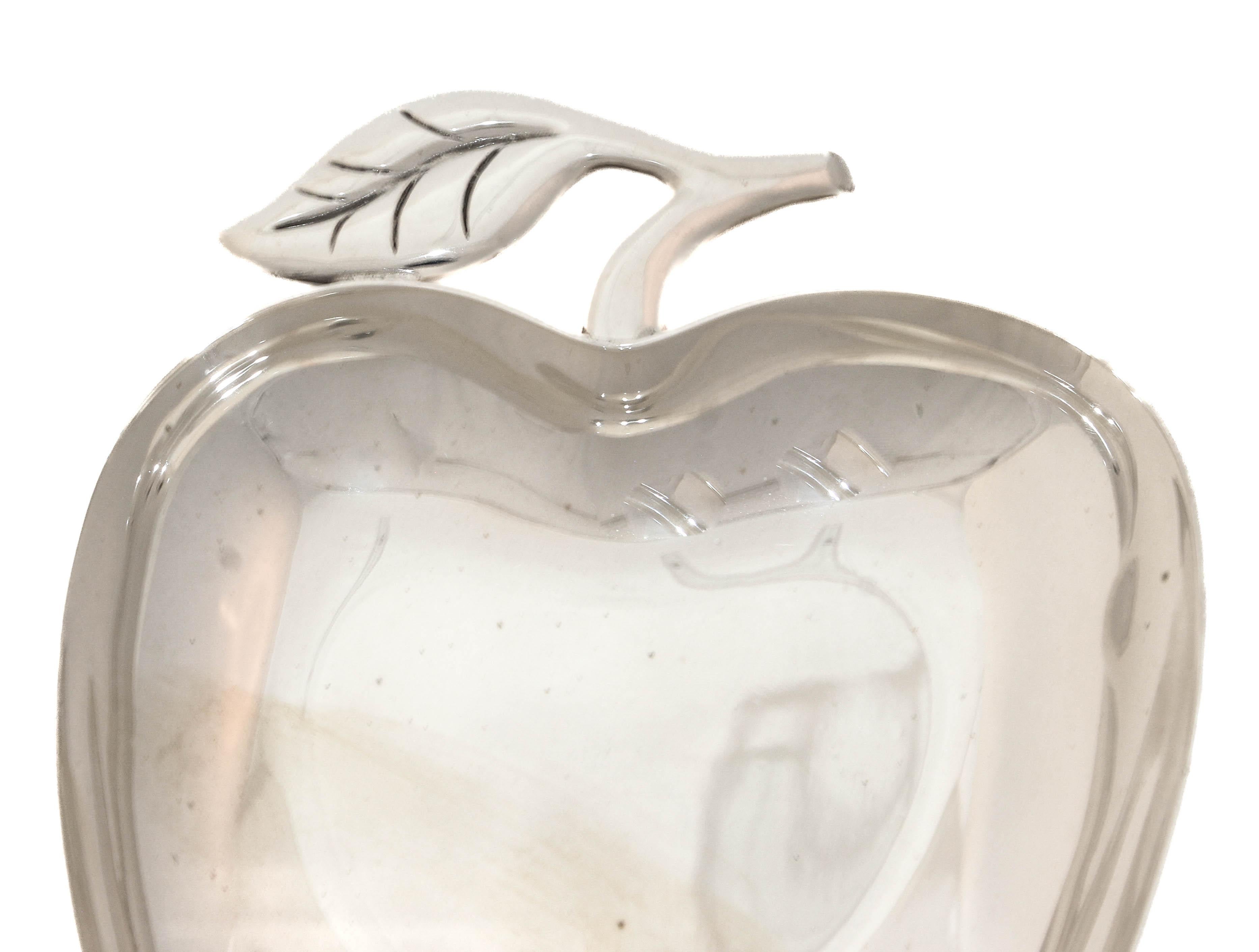 Un delizioso piatto in argento sterling di Tiffany & Company, disegnato a forma di mela. Il piatto presenta contorni morbidamente arrotondati che evocano la forma naturale del frutto, con una superficie lucida che mette in risalto la qualità della